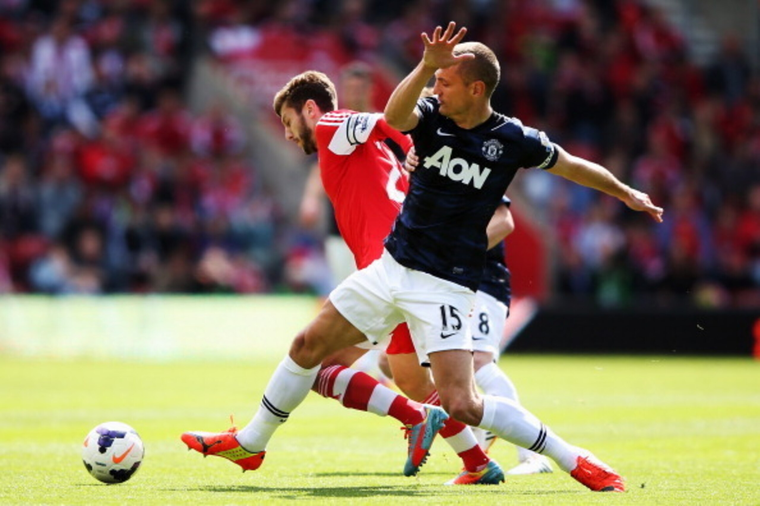 SOUTHAMPTON, ENGLAND - MAY 11:  Nemanja Vidic (R) of Manchester United and Adam Lallana (L) of Southampton challenge for the ball during the Barclays Premier League match between Southampton and Manchester United at St Mary's Stadium on May 11, 2014 in So