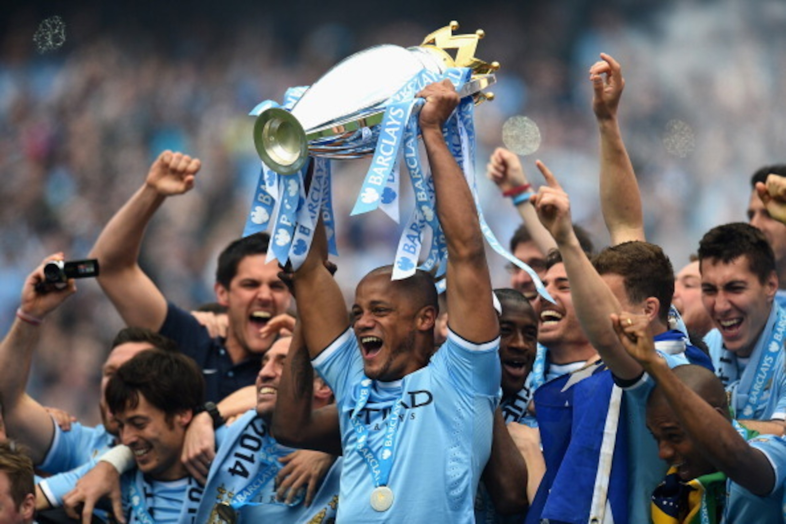 MANCHESTER, ENGLAND - MAY 11:  Vincent Kompany of Manchester City lifts the Premier League trophy at the end of the Barclays Premier League match between Manchester City and West Ham United at the Etihad Stadium on May 11, 2014 in Manchester, England.  (P