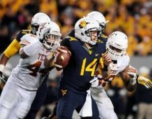 Nov 9, 2013; Morgantown, WV, USA; West Virginia Mountaineers quarterback Paul Millard (14) gets sacked by Texas Longhorns defensive end Jackson Jeffcoat (44) at Milan Puskar Stadium. Mandatory Credit: Evan Habeeb-USA TODAY Sports