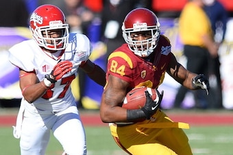 LAS VEGAS, NV - DECEMBER 21:  Darreus Rogers #84 of the USC Trojans runs for yardage ahead of Jonathan Norton #37 of the Fresno State Bulldogs during the Royal Purple Las Vegas Bowl at Sam Boyd Stadium on December 21, 2013 in Las Vegas, Nevada. USC won 45