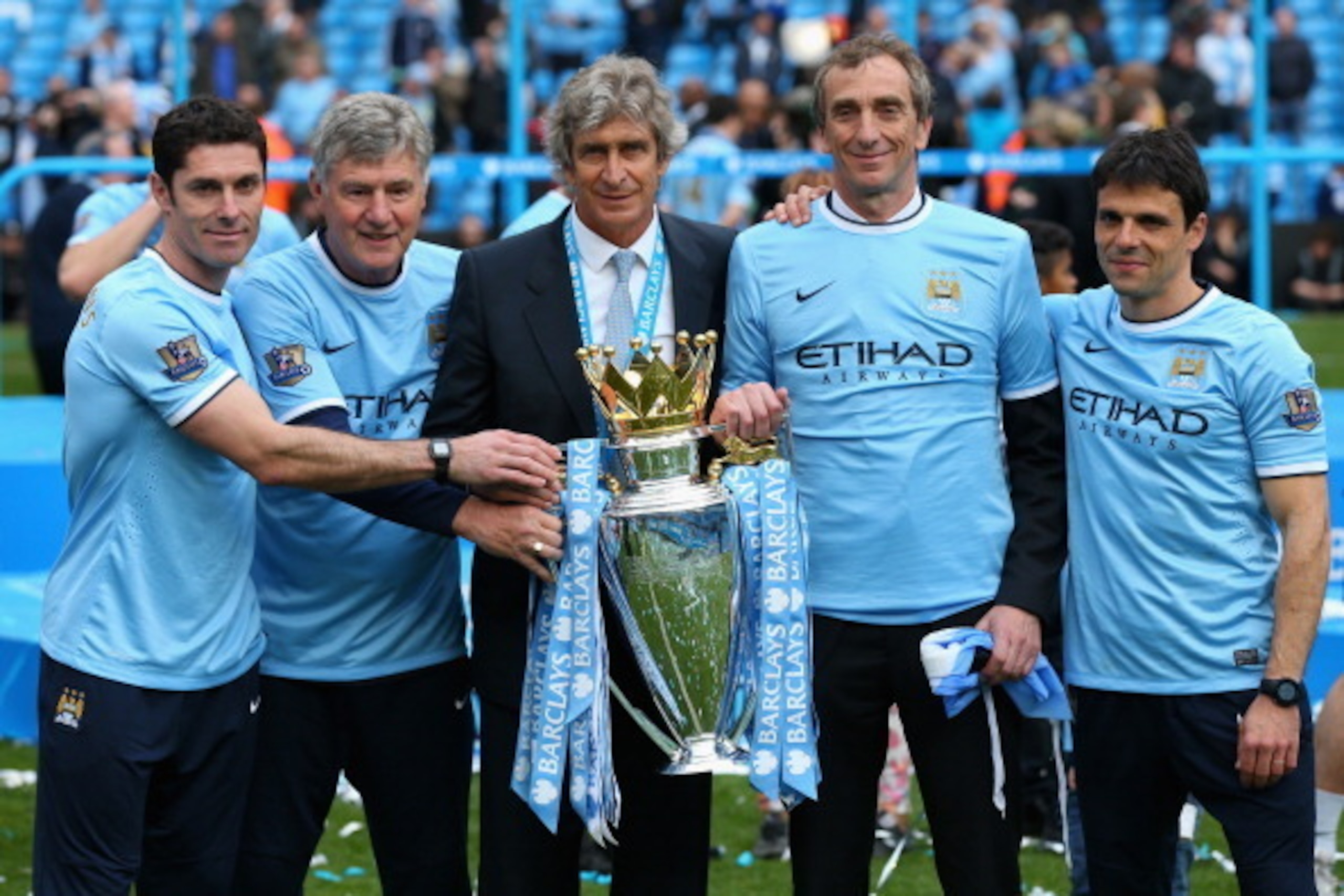 MANCHESTER, ENGLAND - MAY 11:  (L-R) Manchester City Goalkeeping Coach Xabier Mancisidor, Joint Assistant Manager Brian Kidd, Manager Manuel Pellegrini, Joint Assistant Manager Ruben Cousillas and Fitness Coach Jose Cabello pose with the trophy after the 