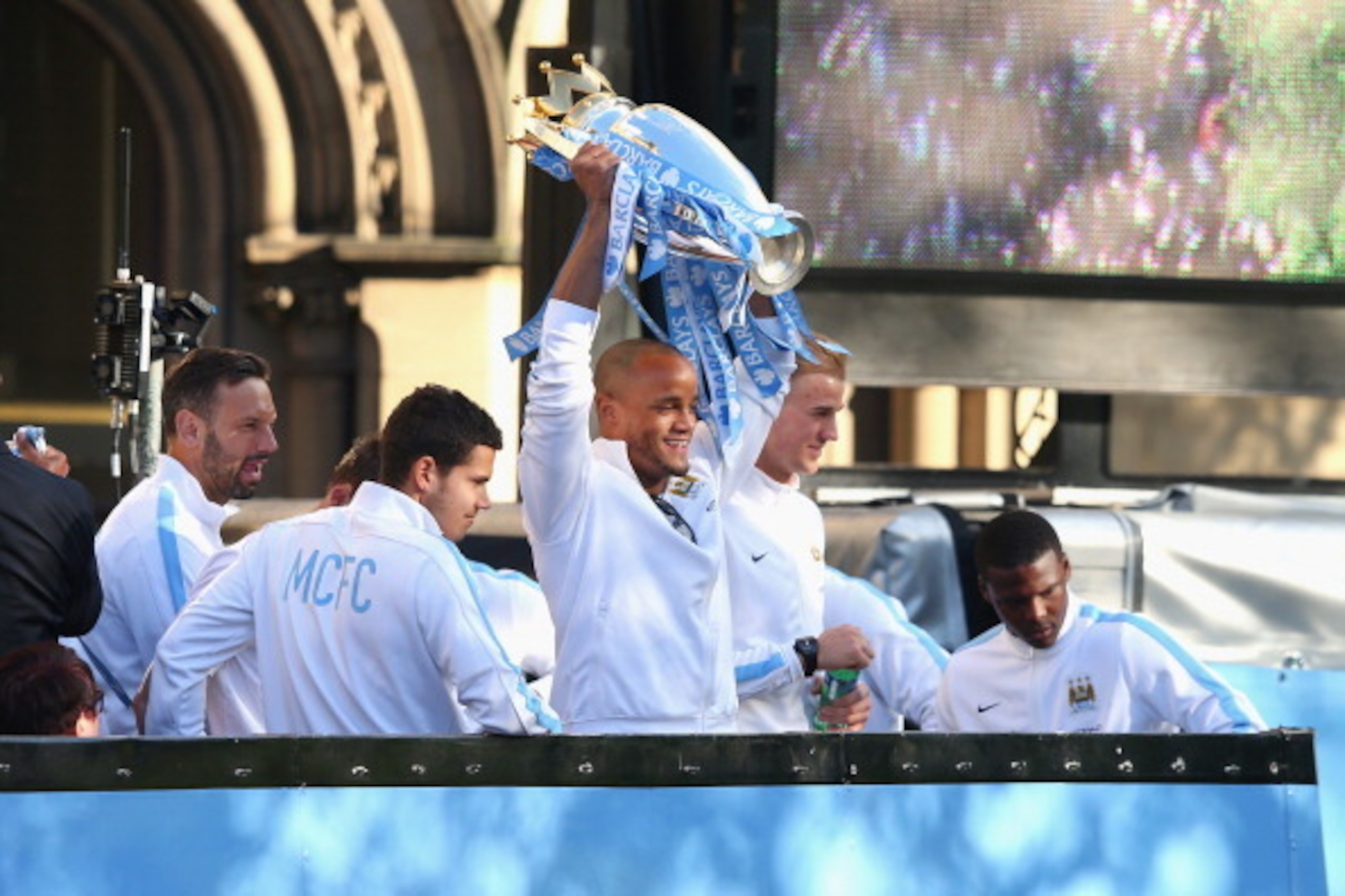 MANCHESTER, ENGLAND - MAY 12:  Vincent Kompany of Manchester City lifts the Barclays Premier League trophy aloft outside Manchester Town Hall at the start of the Manchester City victory parade around the streets of Manchester on May 12, 2014 in Manchester
