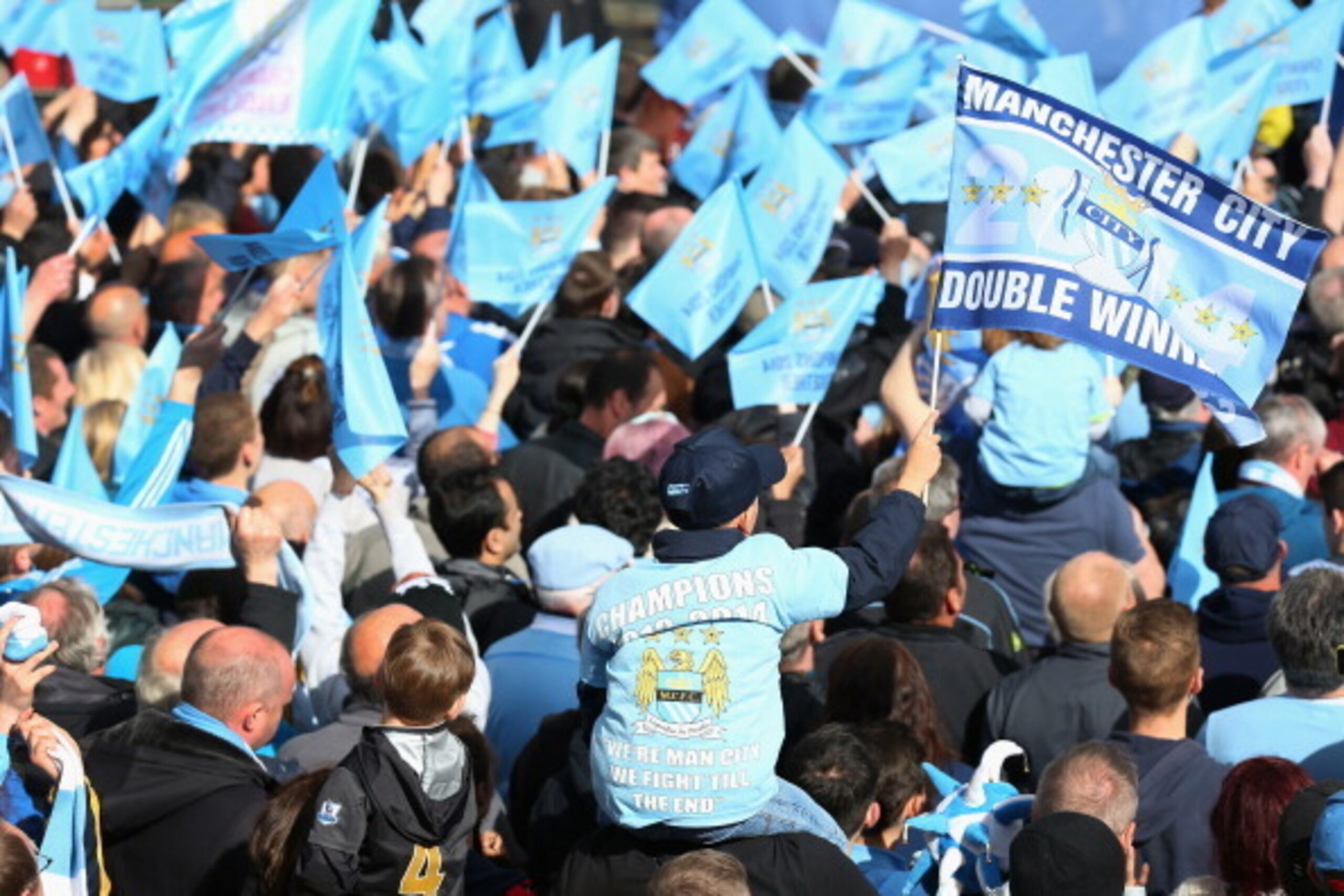 MANCHESTER, ENGLAND - MAY 12:  Supporters of Manchester City wait outside Manchester Town Hall prior to the start of the Manchester City victory parade around the streets of Manchester on May 12, 2014 in Manchester, England.  (Photo by Alex Livesey/Getty 