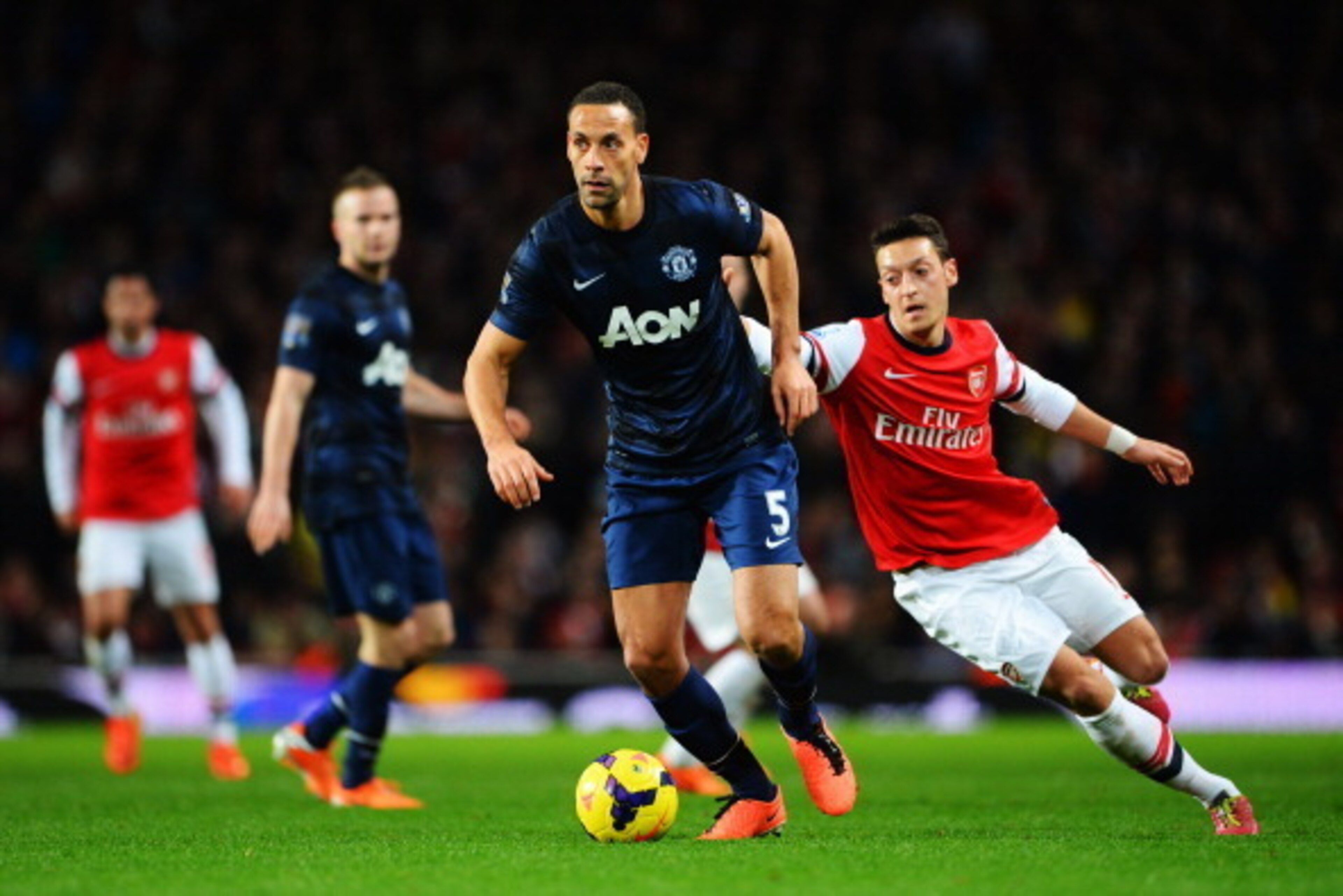 LONDON, ENGLAND - FEBRUARY 12:  Rio Ferdinand of Manchester United holds off the challenge of Mesut Ozil of Arsenal challenge for the ball during the Barclays Premier League match between Arsenal and Manchester United at the Emirates Stadium on February 1