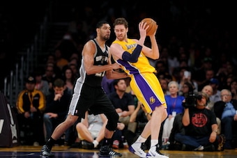 LOS ANGELES, CA - MARCH 19: Pau Gasol #16 of the Los Angeles Lakers handles the ball against Tim Duncan #21 of the San Antonio Spurs at Staples Center on March 19, 2014 in Los Angeles, California. NOTE TO USER: User expressly acknowledges and agrees that,
