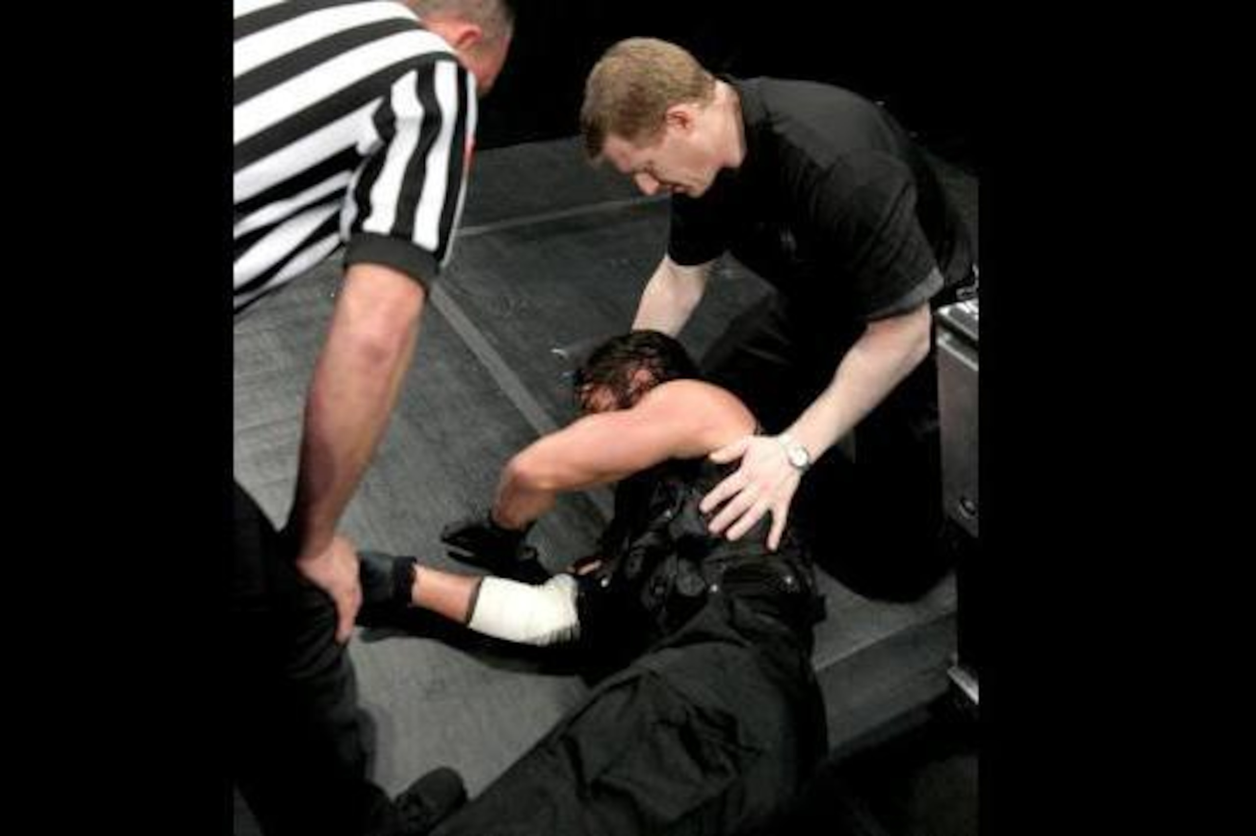Medical staff attend to Seth Rollins.