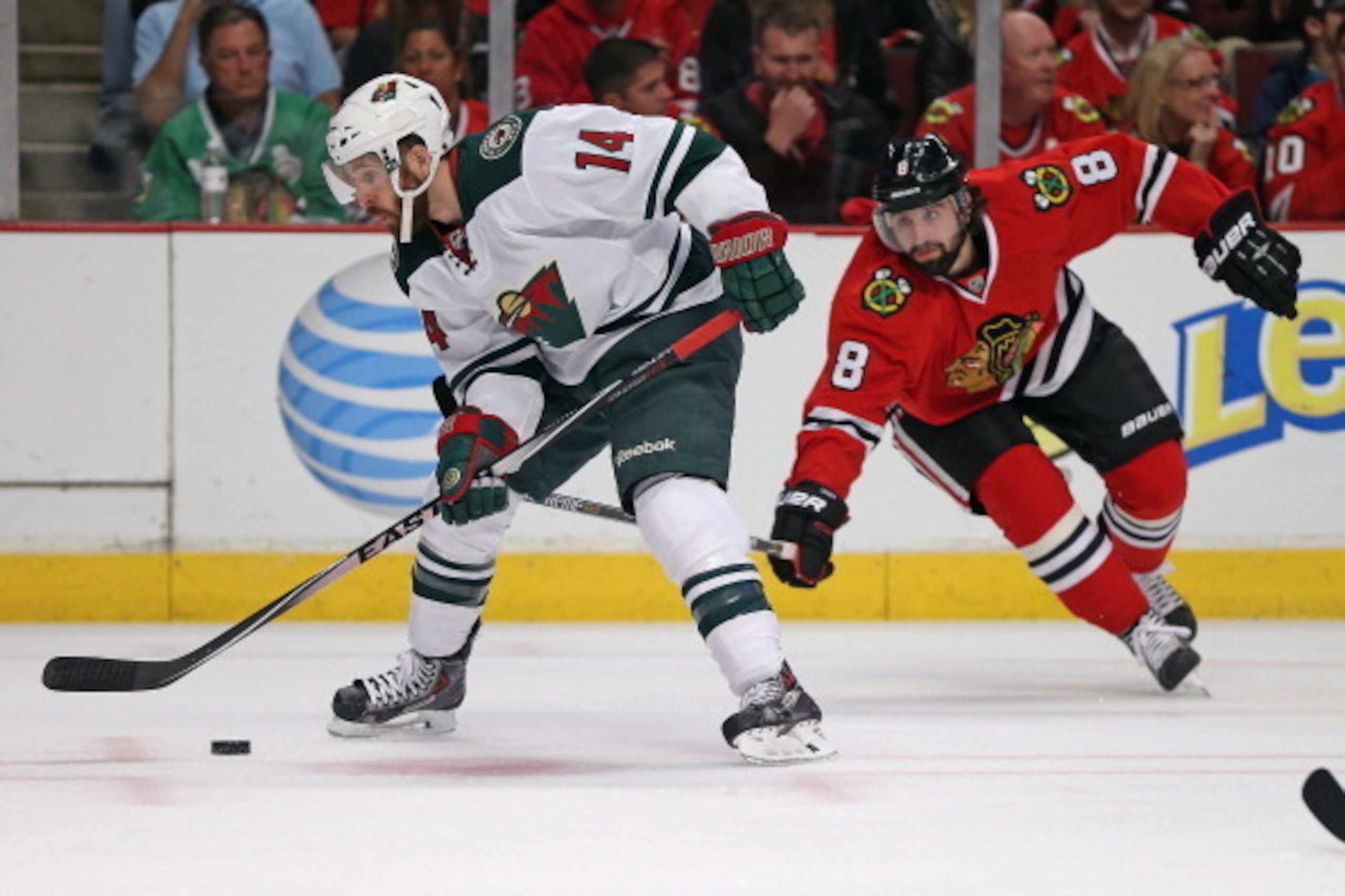 CHICAGO, IL - MAY 11: Justin Fontaine #14 of the Minnesota Wild controls the puck under pressure from Nick Leddy #8 of the Chicago Blackhawks in Game Five of the Second Round of the 2014 NHL Stanley Cup Playoffs at the United Center on May 11, 2014  in Ch
