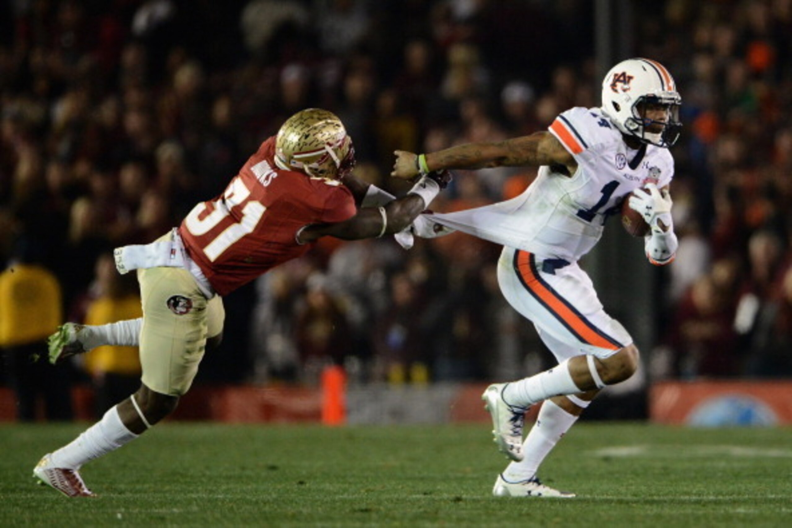 PASADENA, CA - JANUARY 06:  Quarterback Nick Marshall #14 of the Auburn Tigers runs for a first down as defensive back Terrence Brooks #31 of the Florida State Seminoles grabs his jersey during the 2014 Vizio BCS National Championship Game at the Rose Bow