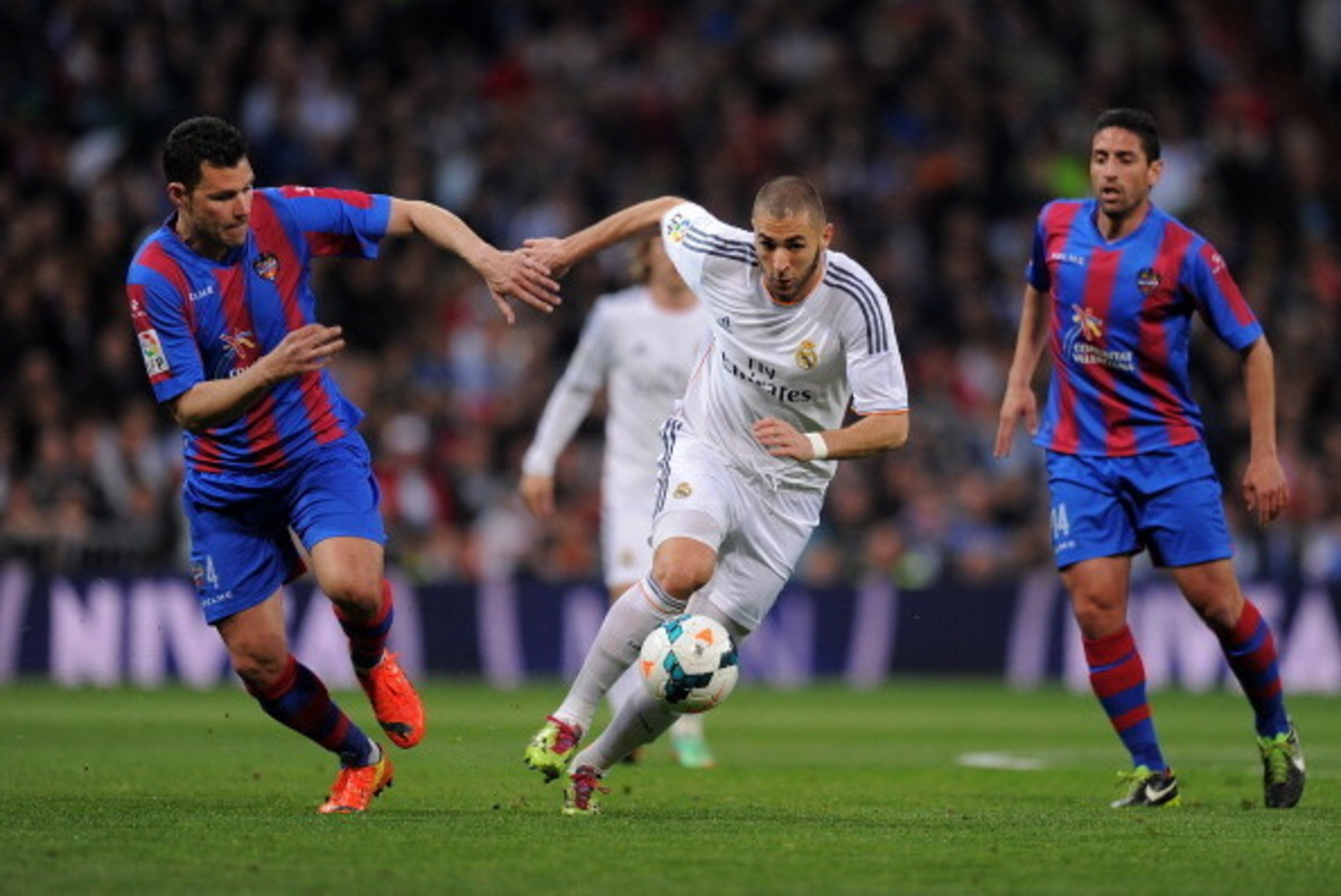 MADRID, SPAIN - MARCH 09:  Karim Benzema (R) of Real Madrid CF is challenged by David Navarro of Levante UD during the La Liga match between Real Madrid CF and Levante UD at Santiago Bernabeu stadium on March 9, 2014 in Madrid, Spain.  (Photo by Denis Doy
