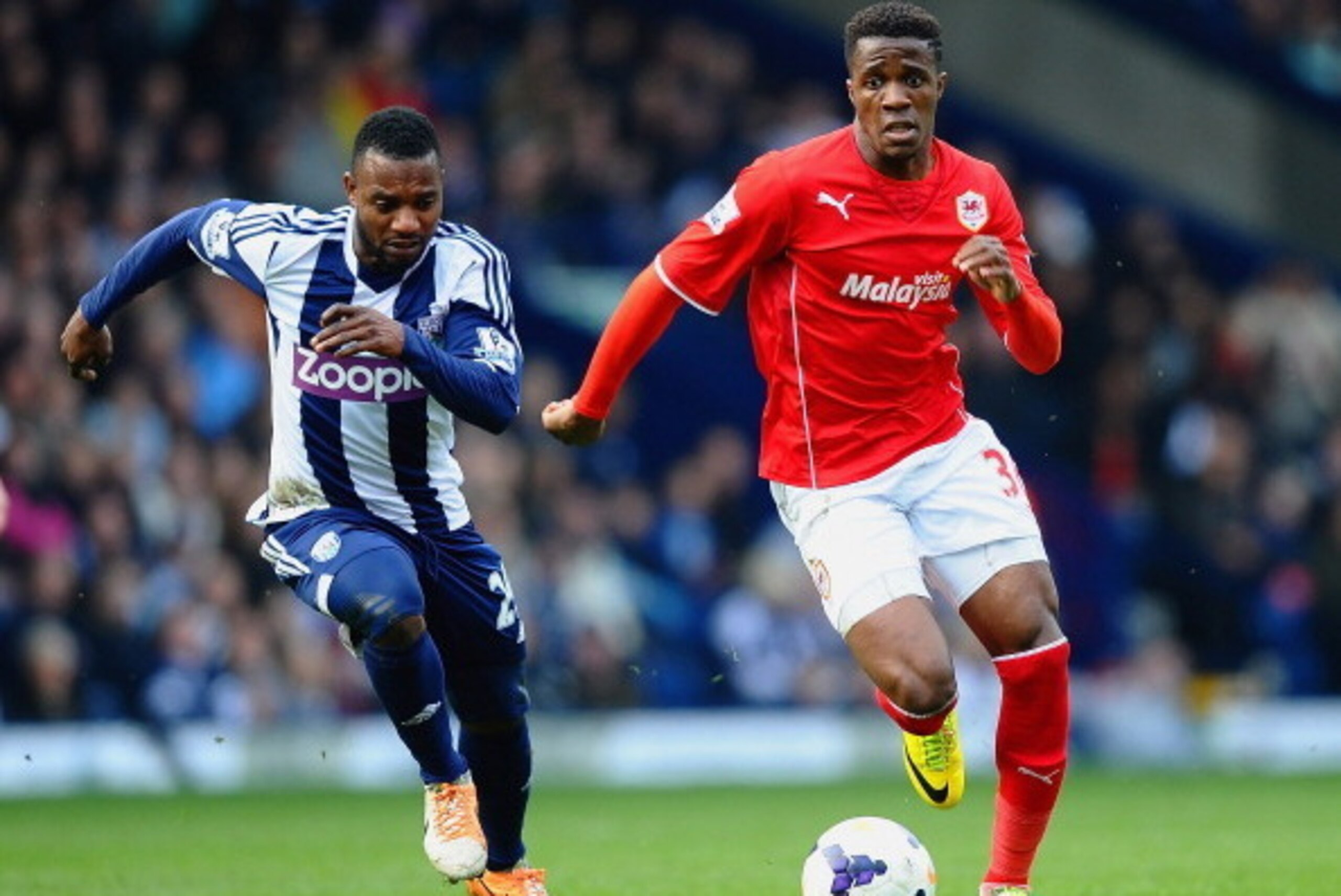 WEST BROMWICH, ENGLAND - MARCH 29: Wilfried Zaha of Cardiff City and Stephane Sessegnon of West Brom compete for the ball during the Barclays Premier League match between West Bromwich Albion and Cardiff City at The Hawthorns on March 29, 2014 in West Bro
