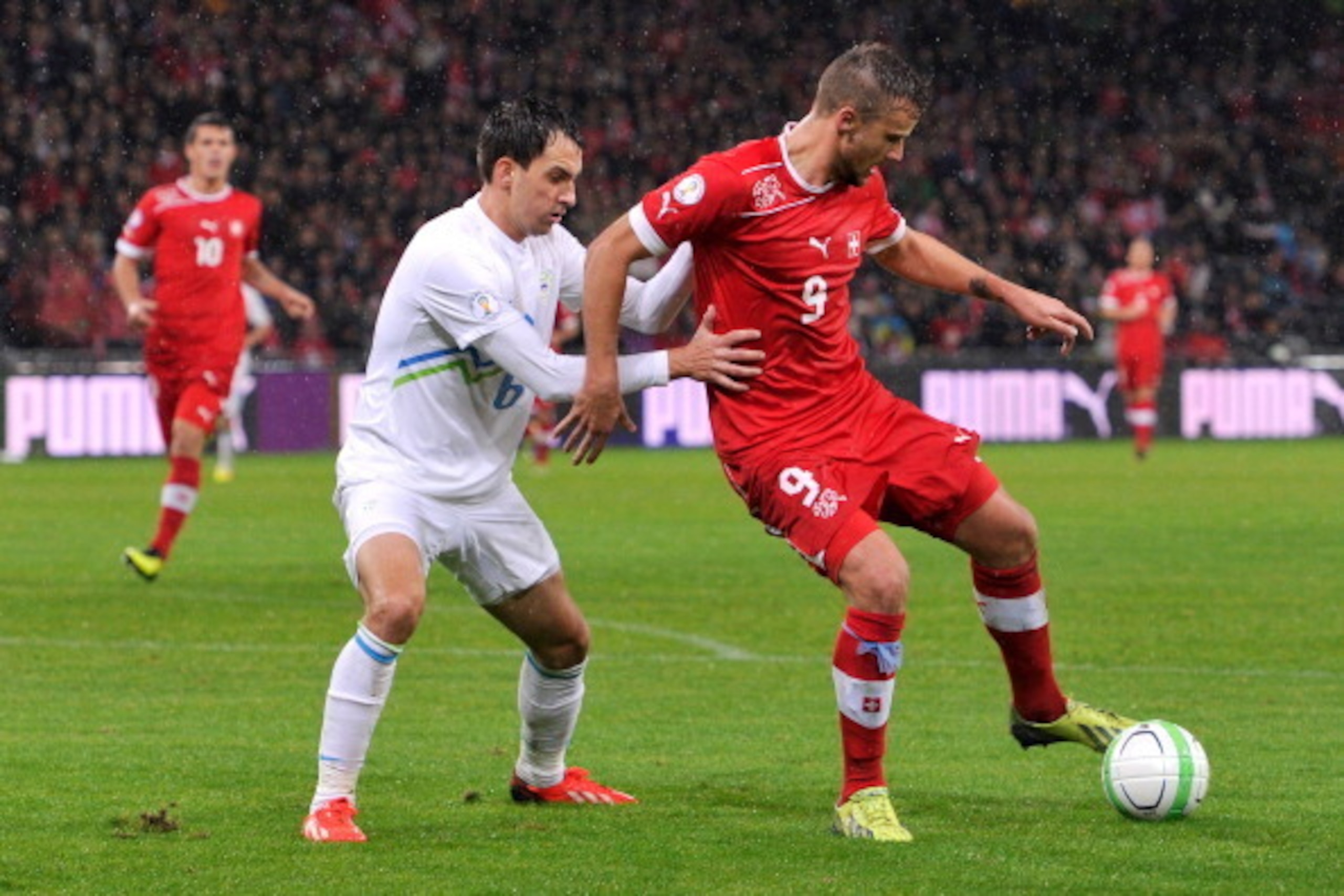 BERN, SWITZERLAND - OCTOBER 15:  Branko Ilic of Slovenia and Haris Seferovic of Switzerland in action during the FIFA 2014 World Cup Qualifier match between Switzerland and Slovenia match held at Stade de Suisse on October 15, 2013 in Bern, Switzerland.  