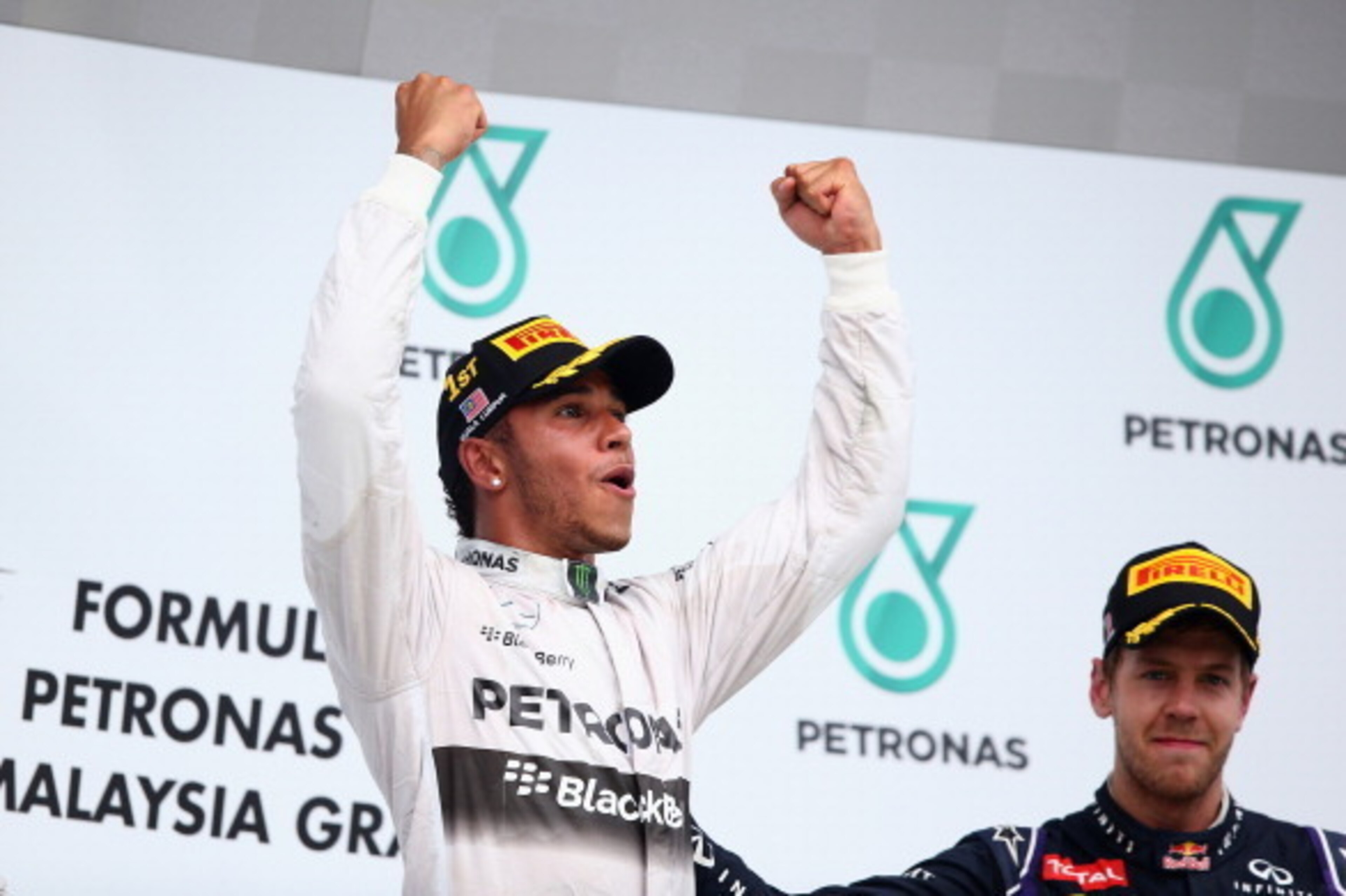 KUALA LUMPUR, MALAYSIA - MARCH 30: Race winner Lewis Hamilton of Great Britain and Mercedes GP (L) celebrates on the podium alongside third placed Sebastian Vettel of Germany and Infiniti Red Bull Racing after the Malaysia Formula One Grand Prix at the S KUALA LUMPUR, MALAYSIA - MARCH 30: Race winner Lewis Hamilton of Great Britain and Mercedes GP (L) celebrates on the podium alongside third placed Sebastian Vettel of Germany and Infiniti Red Bull Racing after the Malaysia Formula One Grand Prix at the S