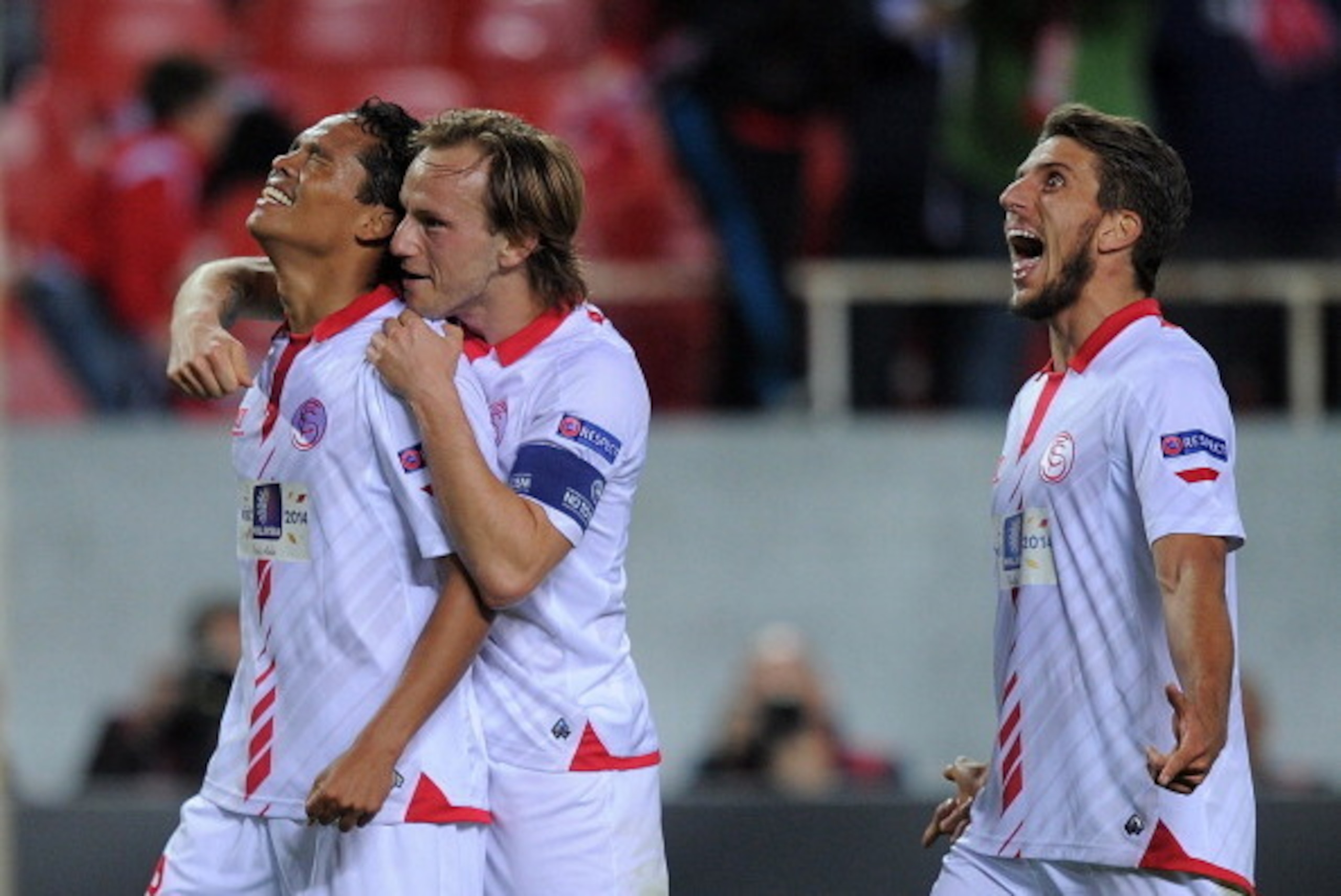 SEVILLE, SPAIN - APRIL 24:  Carlos Bacca (L) of Sevilla FC celebrates with Ivan Rakitic and Daniel Carrico after scoring Sevilla's 2nd goal during the UEFA Europa League Semi Final first leg match between Sevilla FC and Valencia CF at Estadio Ramon Sanche