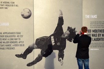 LONDON, ENGLAND - DECEMBER 08: An Arsenal fan takes a photo of a picture of former Arsenal goalkeeper David Seaman ahead of the Barclays Premier League match between Arsenal and Everton at Emirates Stadium on December 8, 2013 in London, England.  (Photo b