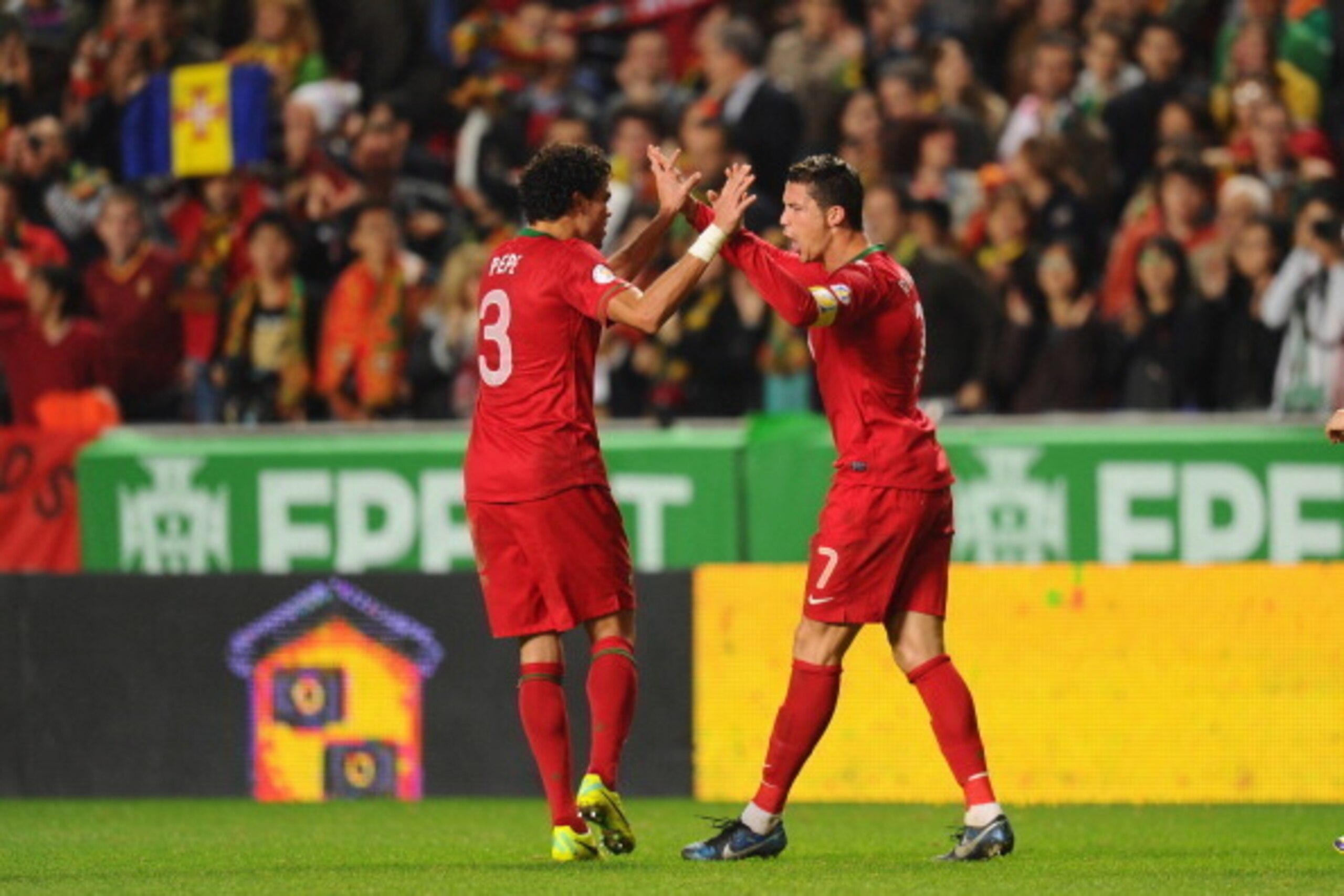 LISBON, PORTUGAL - NOVEMBER 15:  Cristiano Ronaldo of Portugal celebrates after scoring with team mate Pepe during the FIFA 2014 World Cup Qualifier Play-off First Leg between Portugal and Sweden at Estadio da Luz on November 15, 2013 in Lisbon, Portugal.