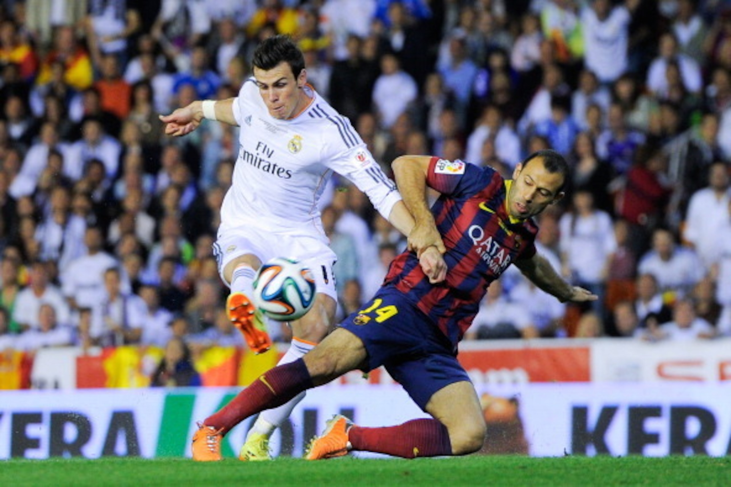 VALENCIA, SPAIN - APRIL 16:  Gareth Bale of Real Madrid CF shoots towards goal under a challenge by Javier Mascherano of FC Barcelona during the Copa del Rey Final between Real Madrid and FC Barcelona at Estadio Mestalla on April 16, 2014 in Valencia, Spa