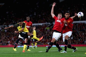 MANCHESTER, ENGLAND - AUGUST 09:   Carlos Bacca of Sevilla shoots at goal past the Manchester United defence during the Rio Ferdinand Testimonial Match between Manchester United and Sevilla at Old Trafford on August 9, 2013 in Manchester, England.  (Photo