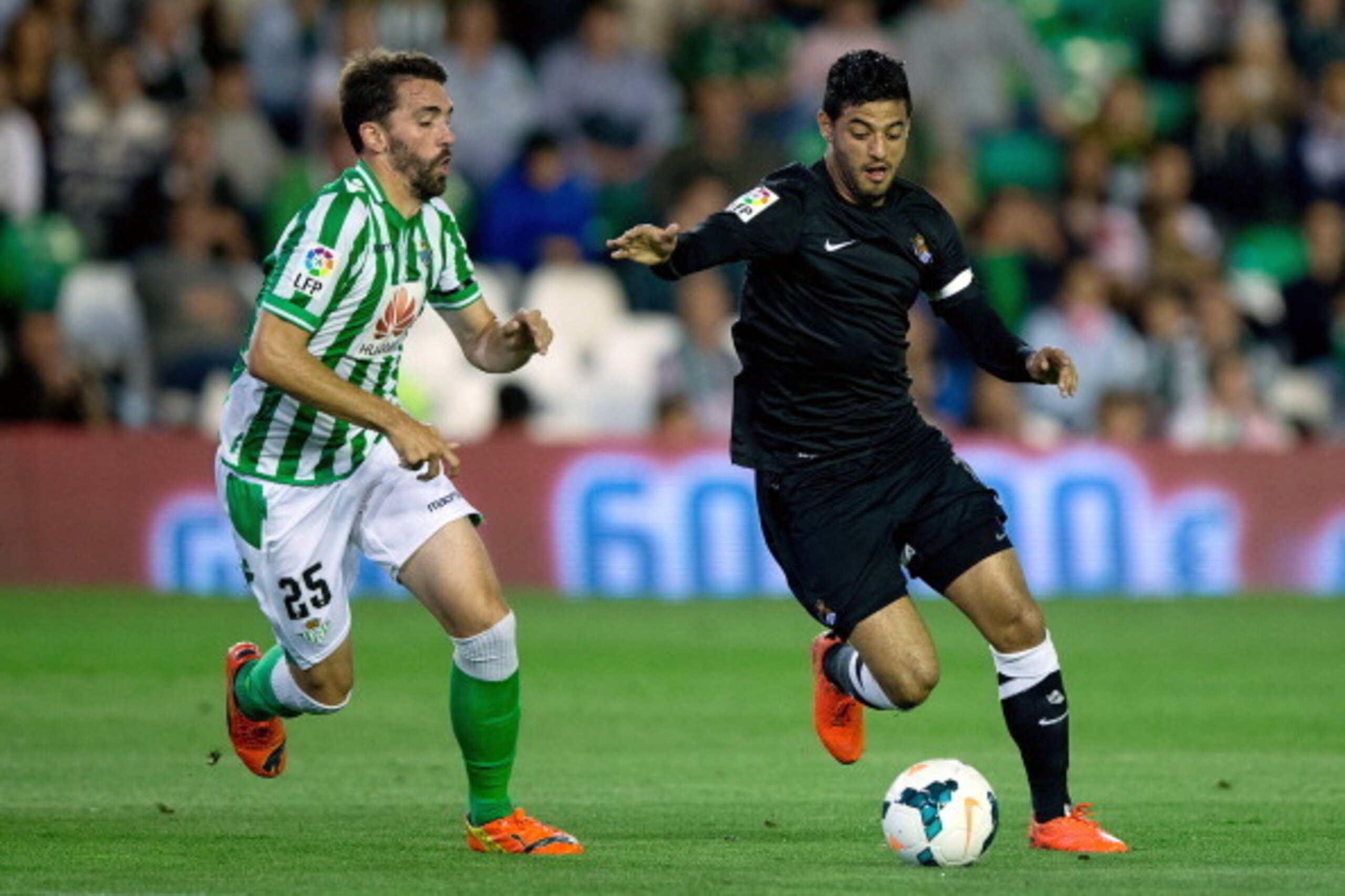 SEVILLE, SPAIN - APRIL 26:  Carlos Vela (R) of Real Sociedad competes for the ball with Jordi Figueras (L) of Real Betis Balompie during the La Liga match between Real Betis Balompie and Real Sociedad de Futbol at Estadio Benito Villamarin on April 26, 20