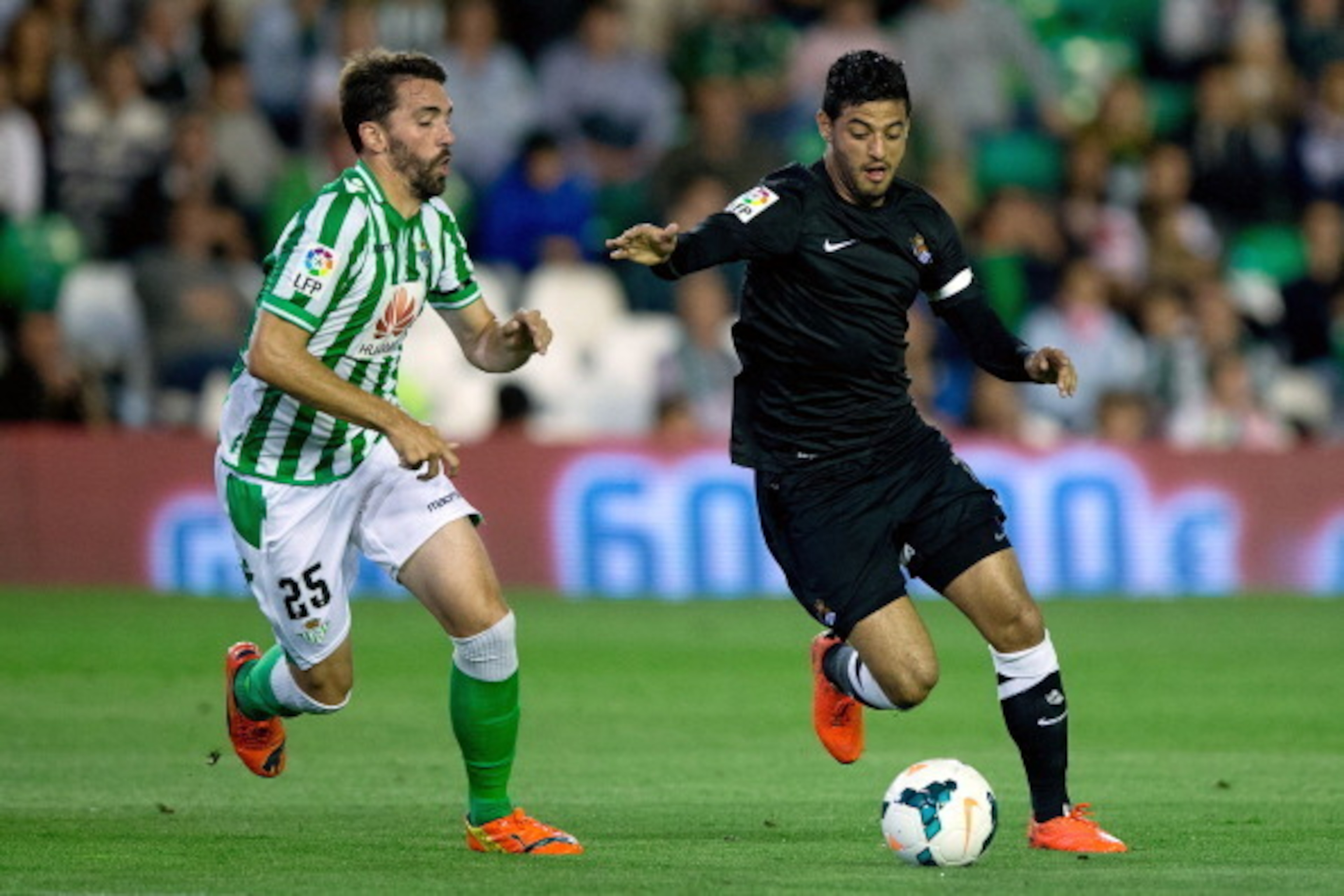 SEVILLE, SPAIN - APRIL 26: Carlos Vela (R) of Real Sociedad competes for the ball with Jordi Figueras (L) of Real Betis Balompie during the La Liga match between Real Betis Balompie and Real Sociedad de Futbol at Estadio Benito Villamarin on April 26, 20 SEVILLE, SPAIN - APRIL 26: Carlos Vela (R) of Real Sociedad competes for the ball with Jordi Figueras (L) of Real Betis Balompie during the La Liga match between Real Betis Balompie and Real Sociedad de Futbol at Estadio Benito Villamarin on April 26, 20