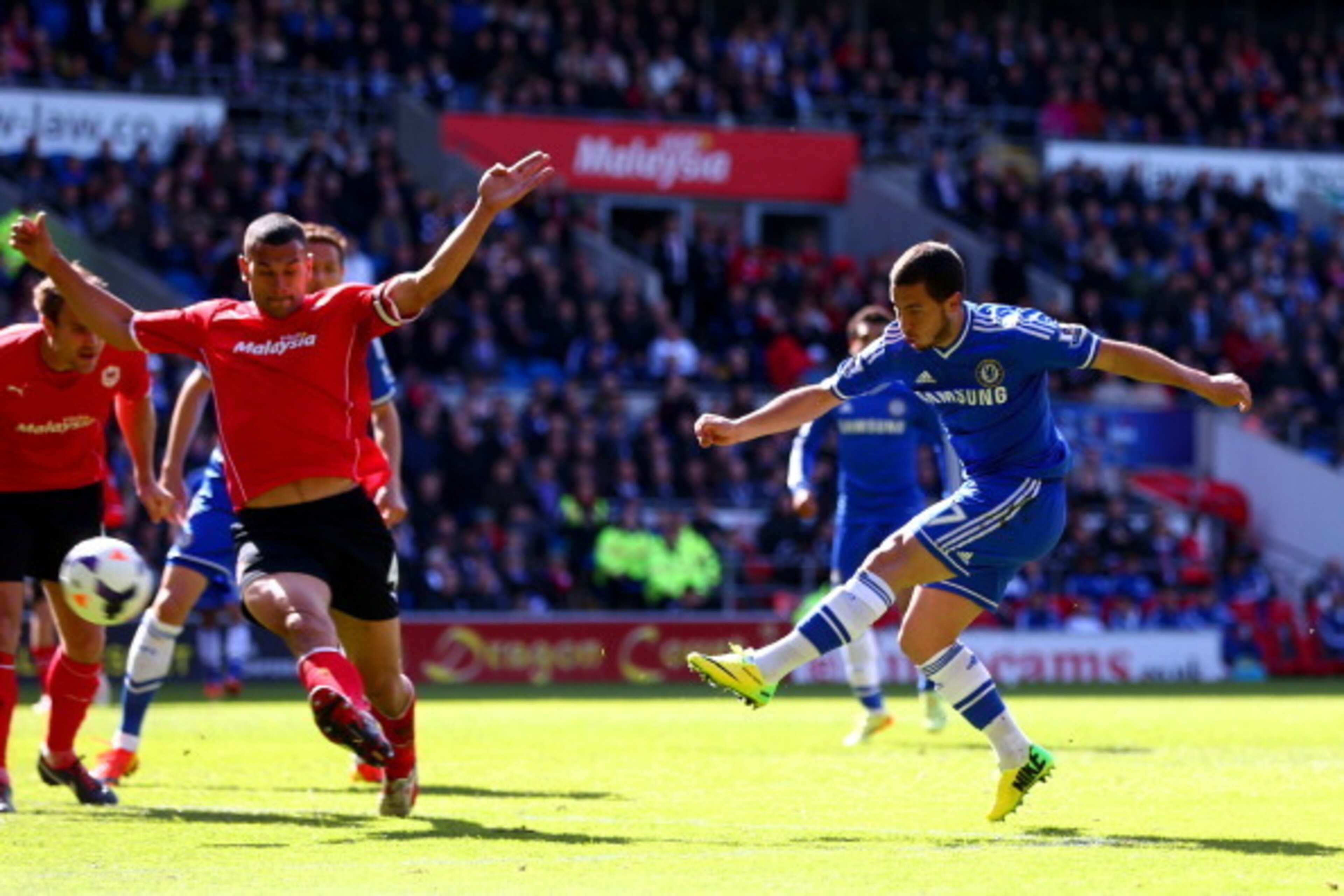 CARDIFF, WALES - MAY 11:  Eden Hazard of Chelsea shoots past Steven Caulker of Cardiff City during the Barclays Premier League match between Cardiff City and Chelsea at Cardiff City Stadium on May 11, 2014 in Cardiff, Wales.  (Photo by Michael Steele/Gett