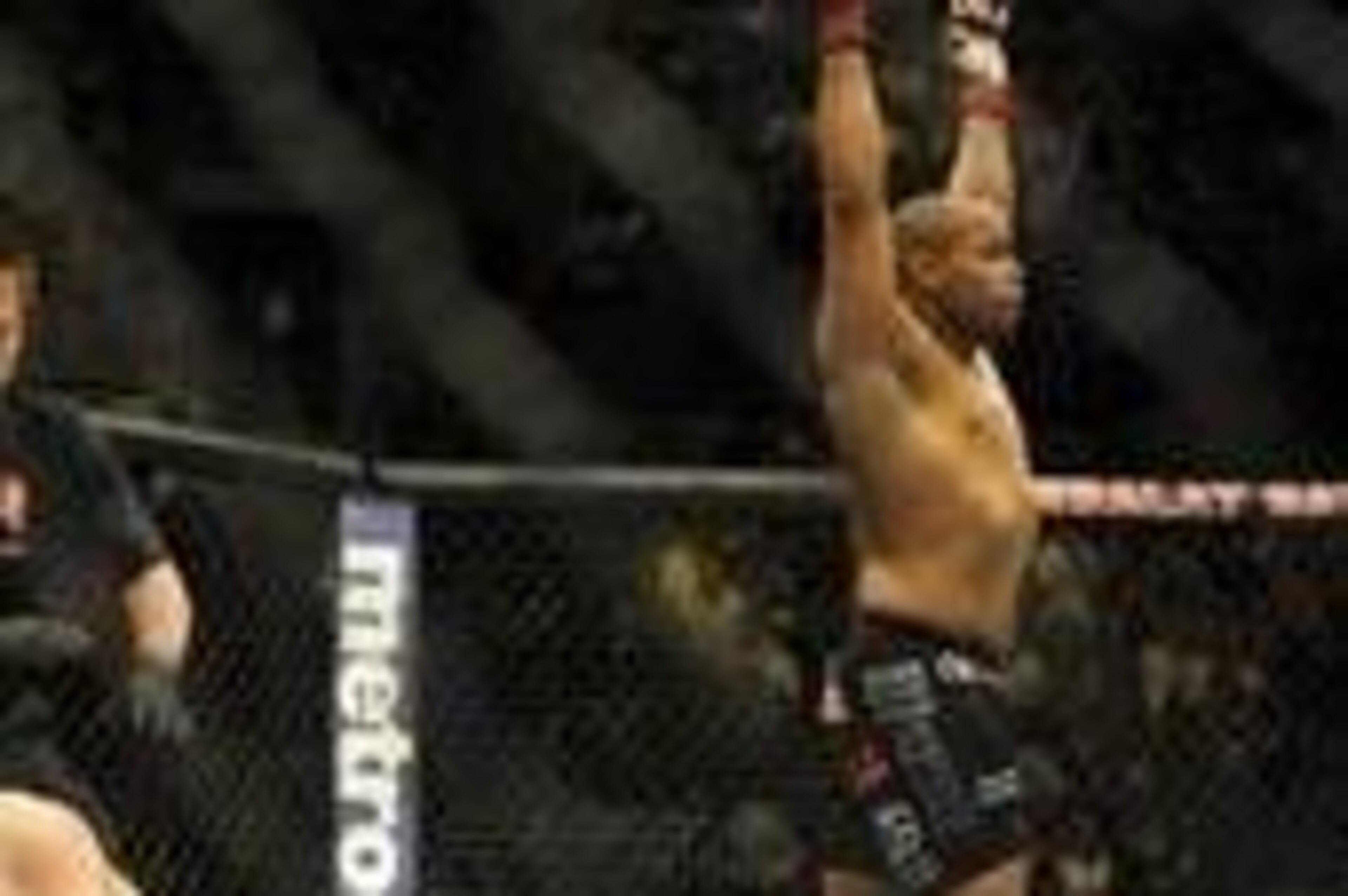 Feb 22, 2014; Las Vegas, NV, USA; Patrick Cummins (blue gloves) throws his hands up as Daniel Cormier lies on the mat after the referee stops their UFC light heavyweight bout at Mandalay Bay. Cormier won by way of a TKO in the first round. Mandatory Credi