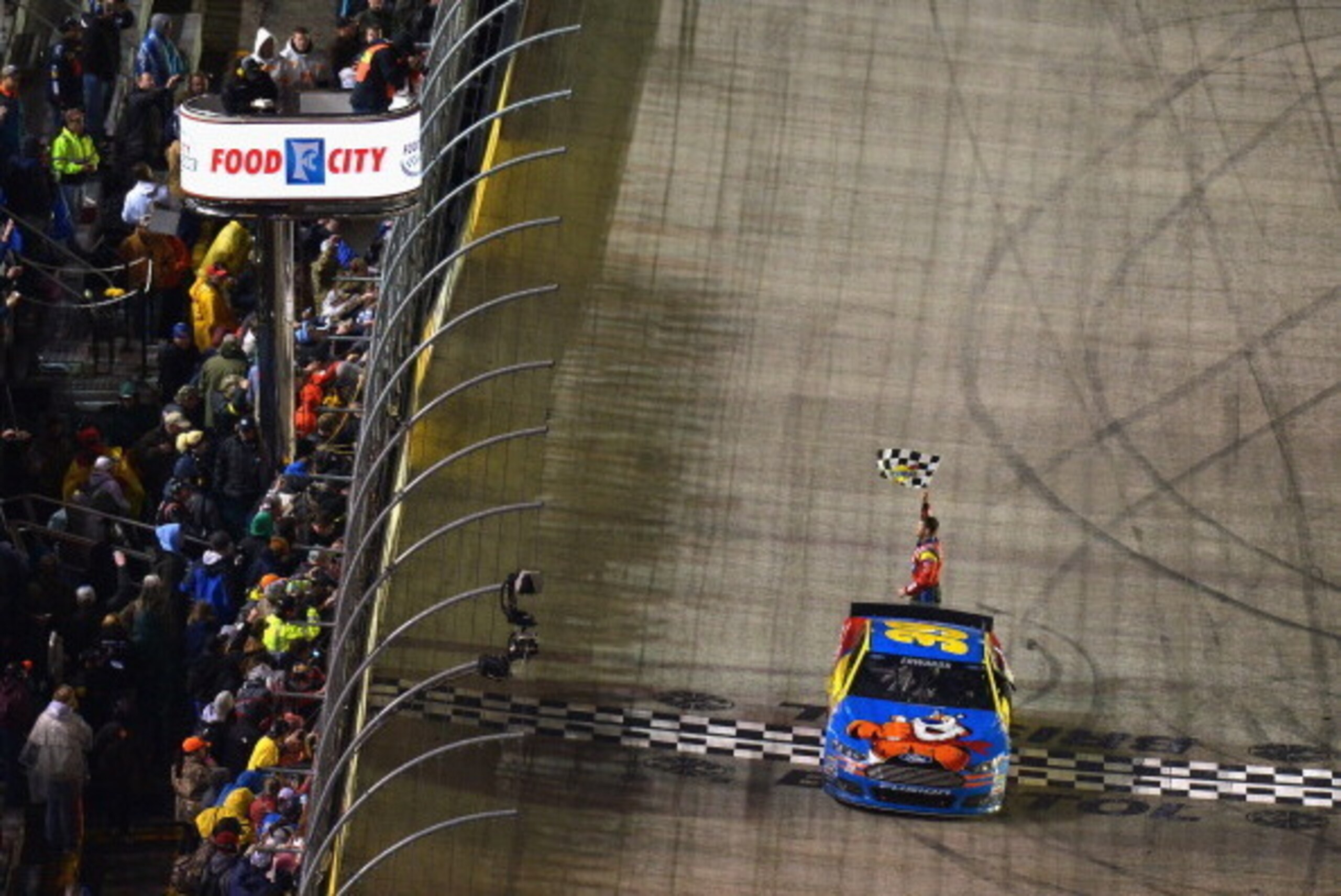 BRISTOL, TN - MARCH 16: Carl Edwards, driver of the #99 Kellogg's / Frosted Flakes Ford, celebrates with the checkered flag after winning the NASCAR Sprint Cup Series Food City 500 at Bristol Motor Speedway on March 16, 2014 in Bristol, Tennessee.  (Photo