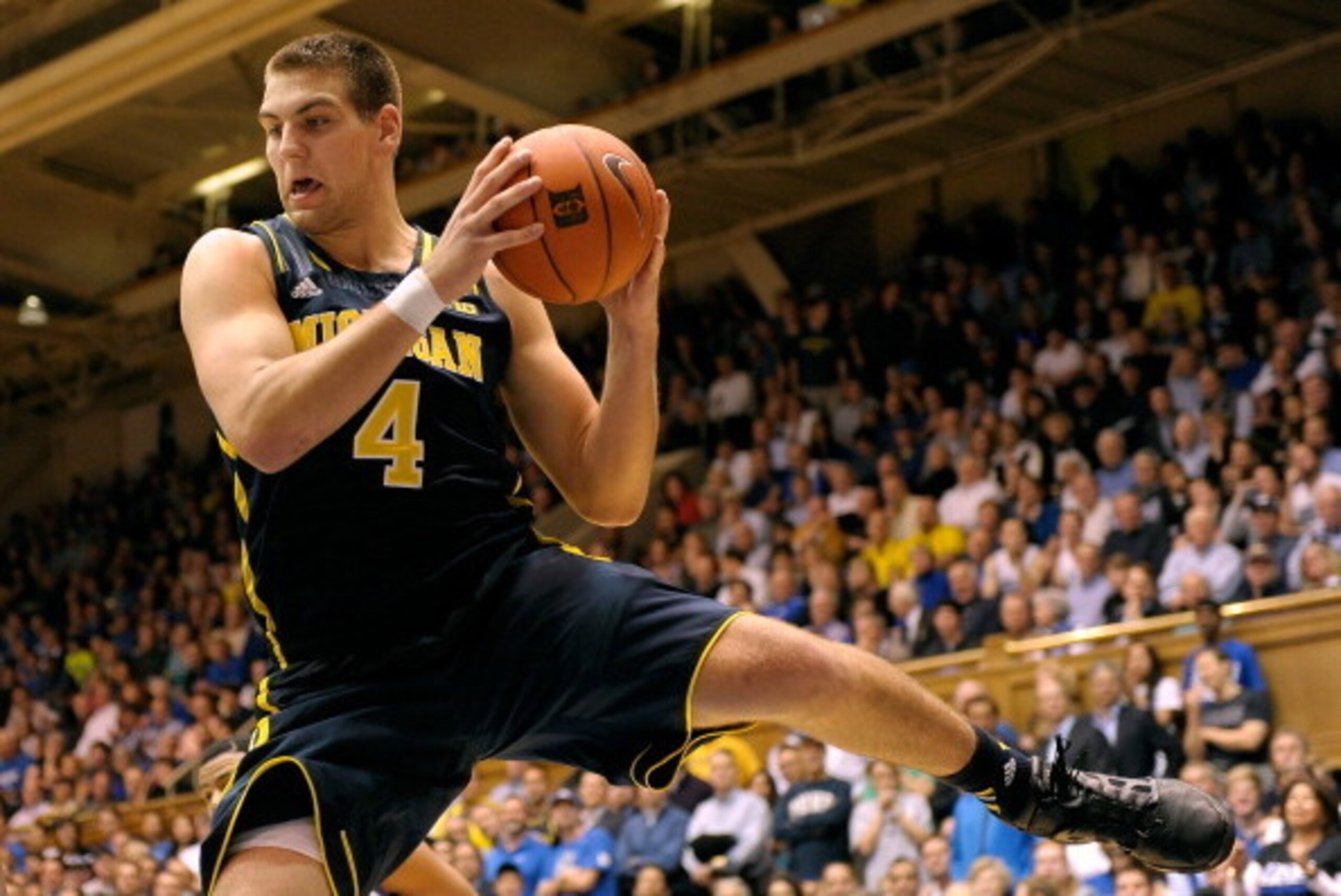 DURHAM, NC - DECEMBER 03:  Mitch McGary #4 of the Michigan Wolverines pulls down a rebound against the Duke Blue Devils at Cameron Indoor Stadium on December 3, 2013 in Durham, North Carolina. Duke won 79-69.  (Photo by Grant Halverson/Getty Images)