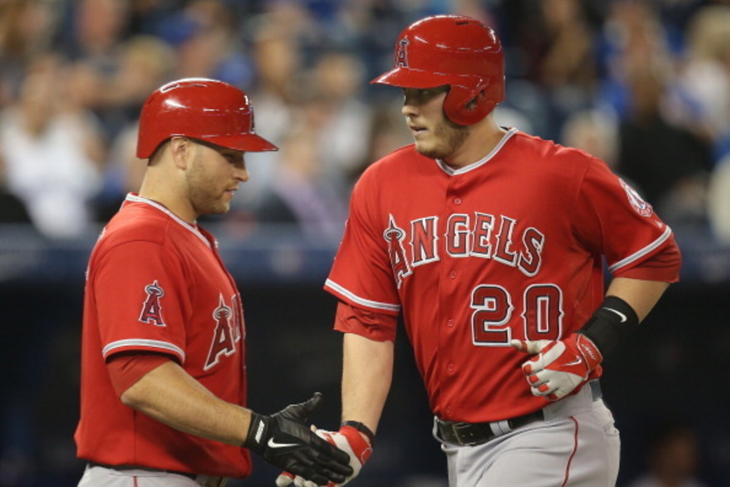 TORONTO, CANADA - MAY 12:  C.J. Cron #20 of the Los Angeles Angels of Anaheim is congratulated by Chris Iannetta #17 after hitting a solo home run in the eighth inning during MLB game action against the Toronto Blue Jays on May 12, 2014 at Rogers Centre i