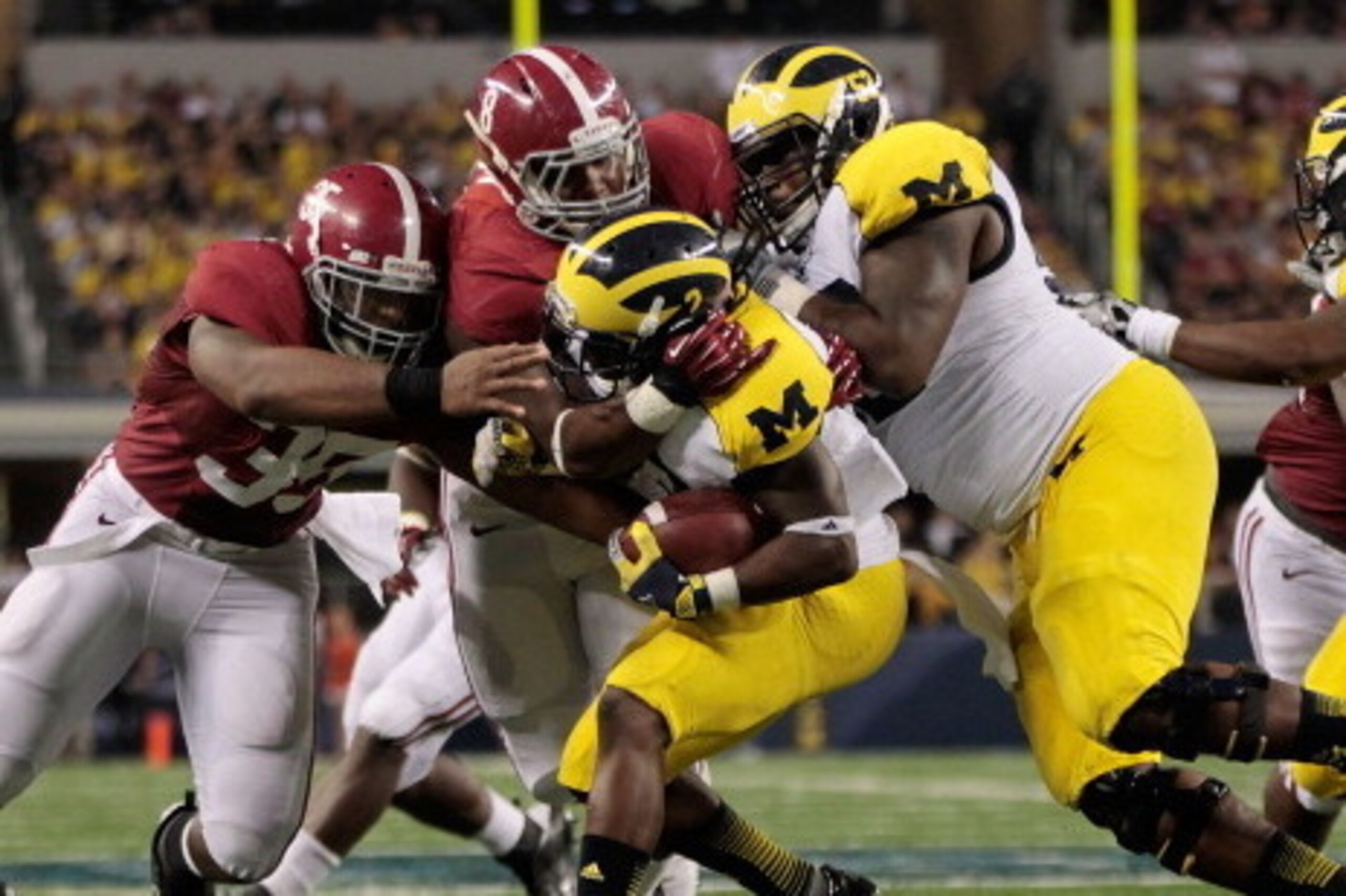 ARLINGTON, TX - SEPTEMBER 01:  The Alabama defense swarms Denard Robinson #16 of Michigan during the  third quarter of the game at Cowboys Stadium on September 1, 2012 in Arlington, Texas. Alabama defeated Michigan 41-14.  (Photo by Leon Halip/Getty Image