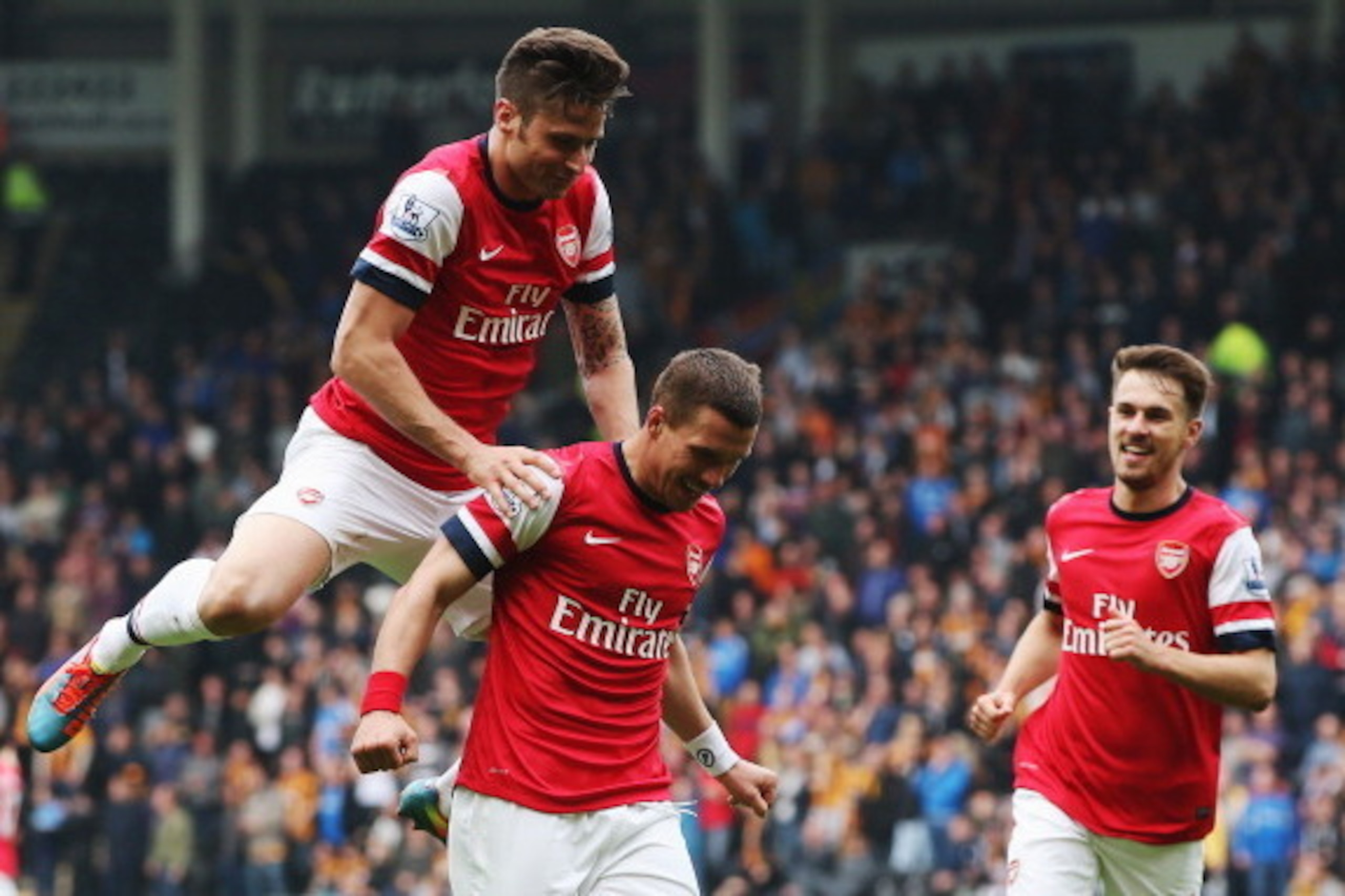 HULL, ENGLAND - APRIL 20:  Lukas Podolski (C) of Arsenal celebrates with team mates Olivier Giroud (L) and Aaron Ramsey (R) after scoring his sides second goal during the Barclays Premier League match between Hull City and Arsenal at KC Stadium on April 2