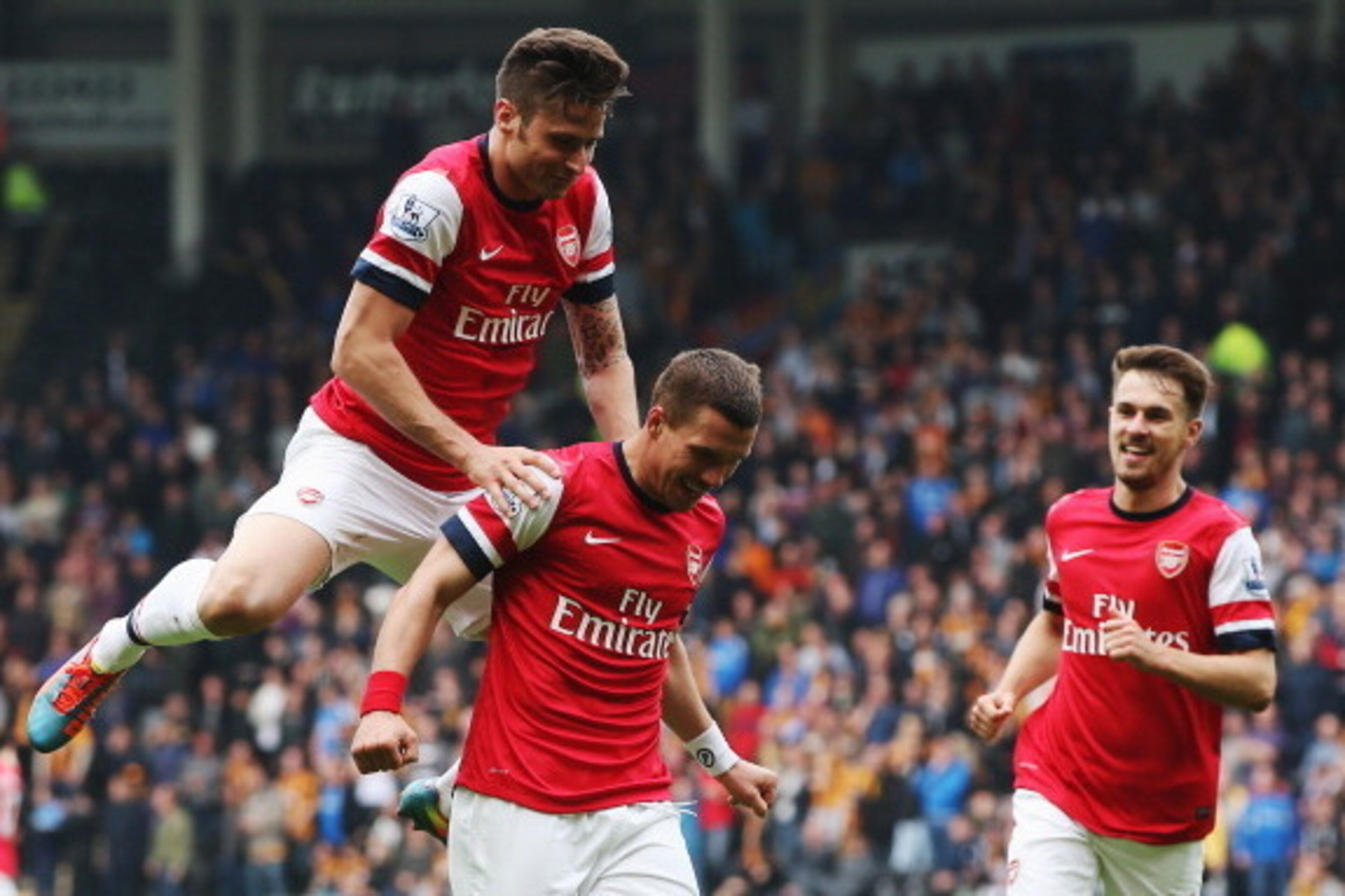 HULL, ENGLAND - APRIL 20: Lukas Podolski (C) of Arsenal celebrates with team mates Olivier Giroud (L) and Aaron Ramsey (R) after scoring his sides second goal during the Barclays Premier League match between Hull City and Arsenal at KC Stadium on April 2 HULL, ENGLAND - APRIL 20: Lukas Podolski (C) of Arsenal celebrates with team mates Olivier Giroud (L) and Aaron Ramsey (R) after scoring his sides second goal during the Barclays Premier League match between Hull City and Arsenal at KC Stadium on April 2