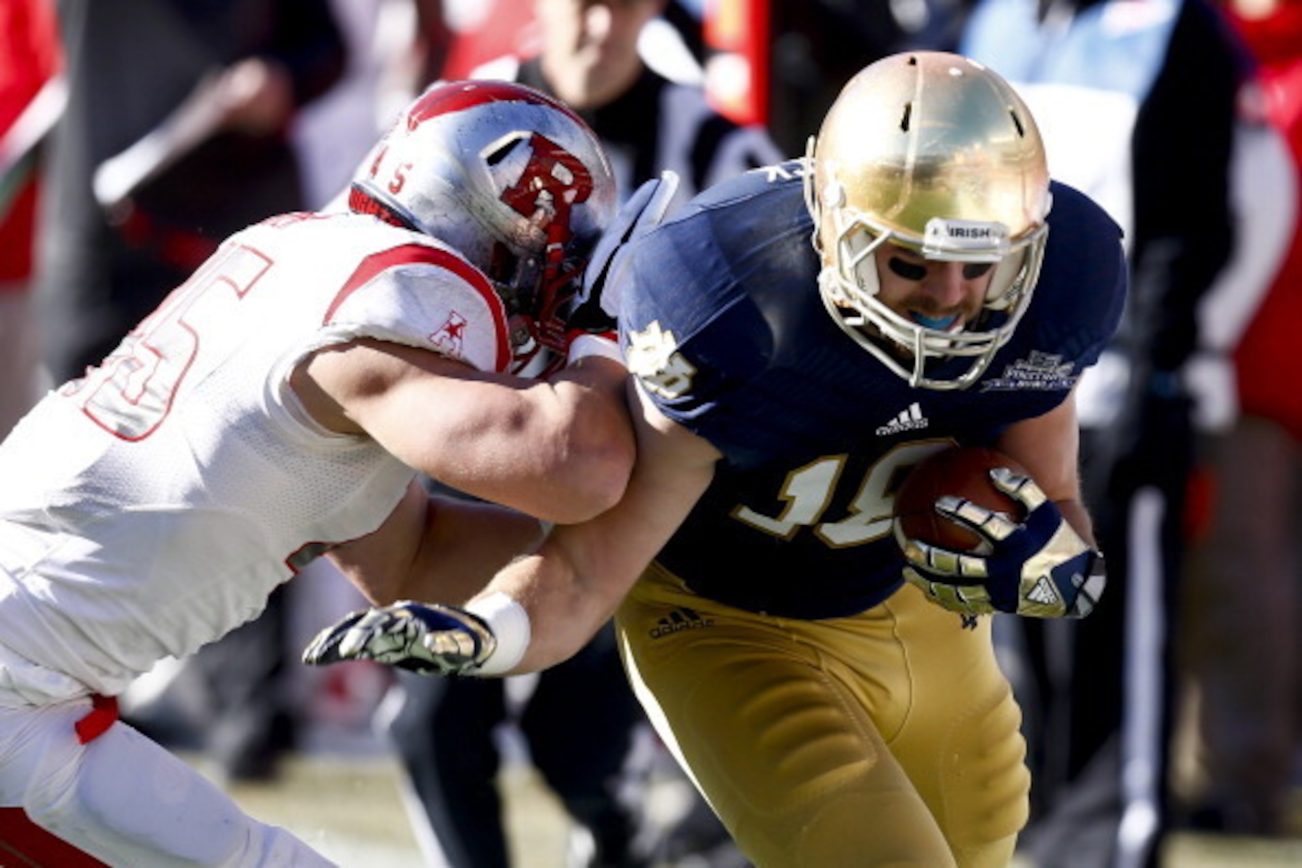 NEW YORK, NY - DECEMBER 28:  Kevin Snyder #45 of the Rutgers Scarlet Knights shoves Ben Koyack #18 of the Notre Dame Fighting Irish during the New Era Pinstripe Bowl bat Yankee Stadium on December 28, 2013 in the Bronx borough of New York City.  (Photo by