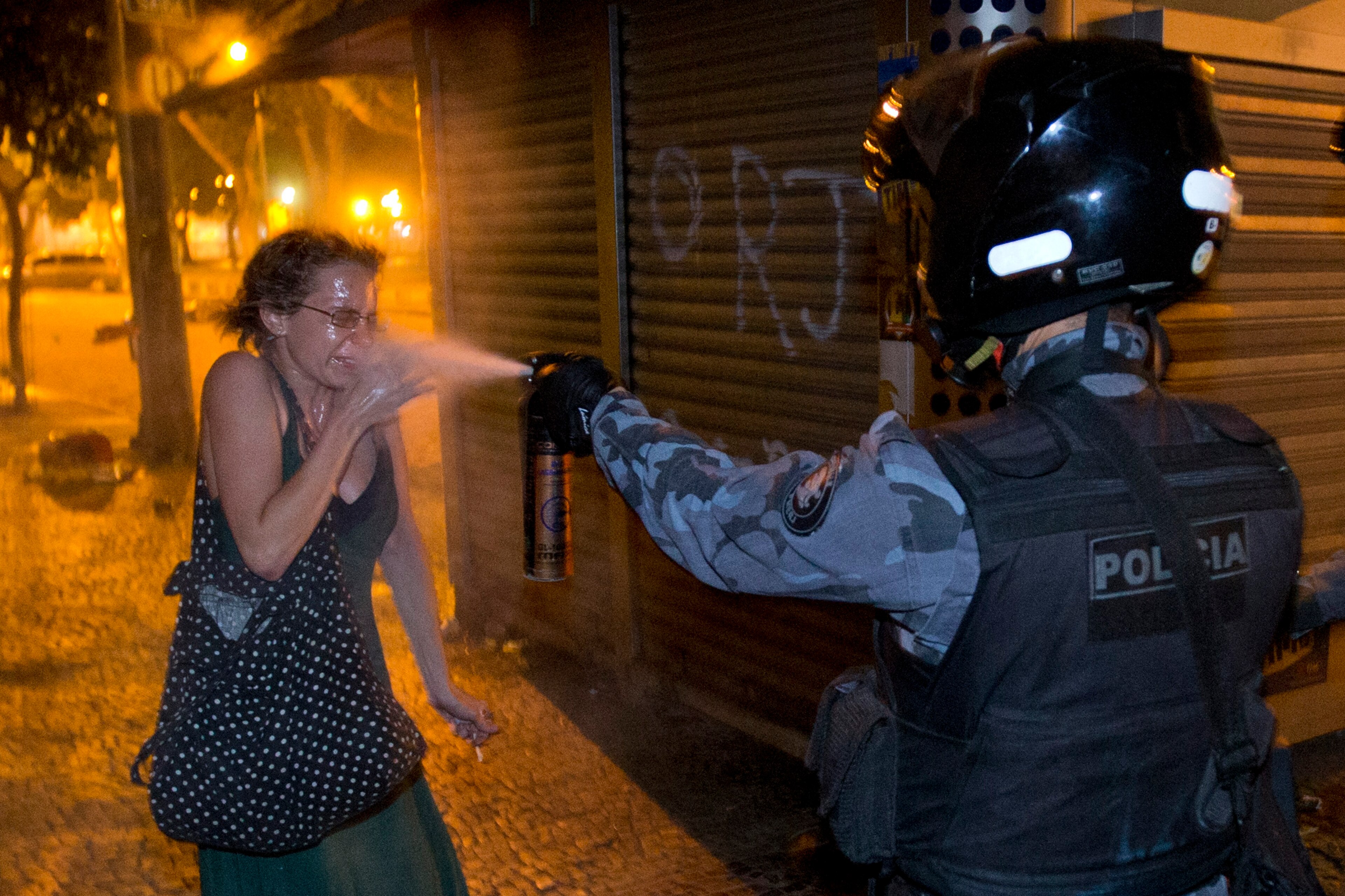 A protester in Rio de Janeiro is doused with tear gas by a member of the Brazilian police. A protester in Rio de Janeiro is doused with tear gas by a member of the Brazilian police.