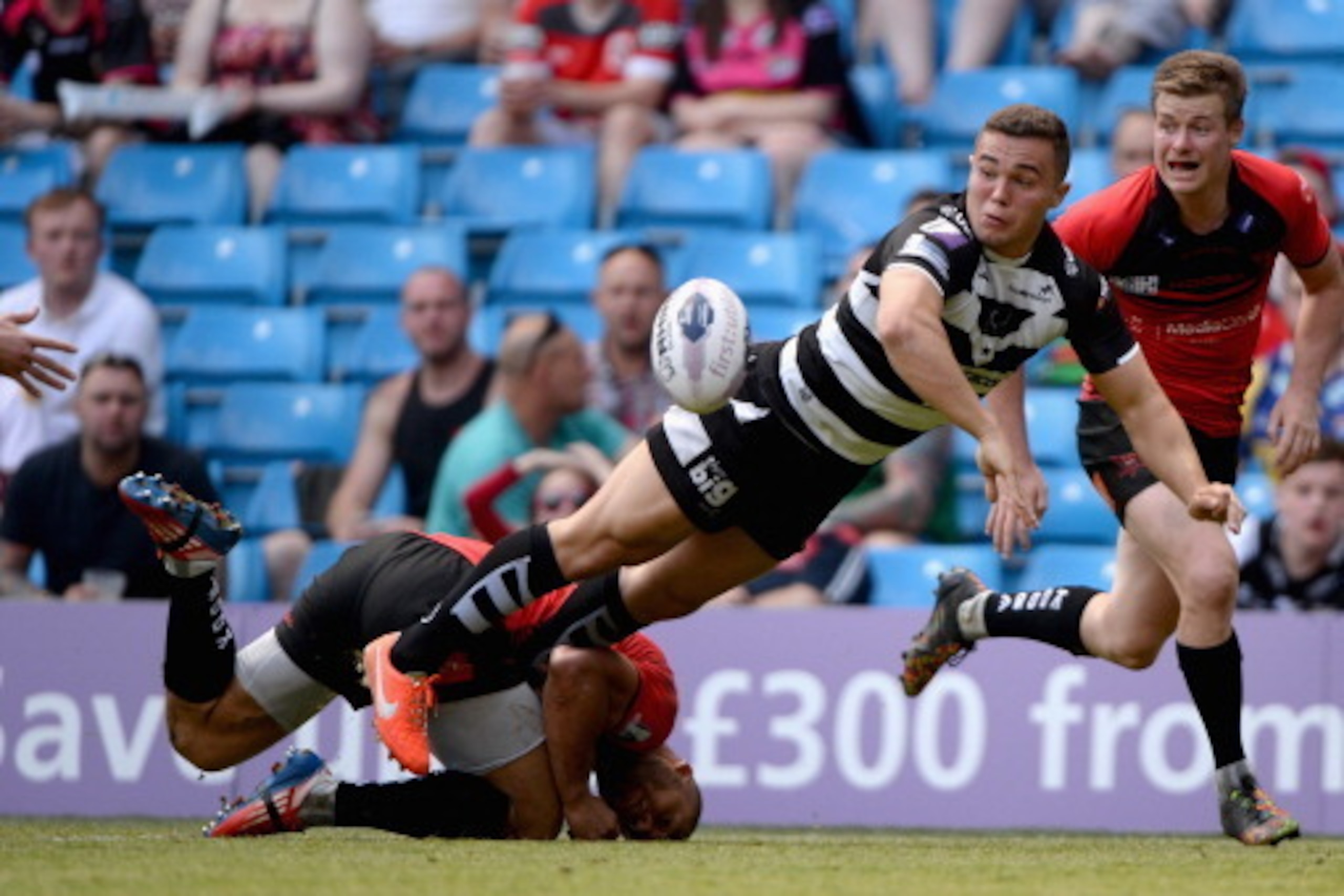 MANCHESTER, ENGLAND - MAY 17: Jack Owens of Widnes Vikings offloads underpressure from Danny Williams and Jake Mullaney of Salford Red Devils during the Super League match between Widnes Vikings and Salford Red Devils at Etihad Stadium on May 17, 2014 in MANCHESTER, ENGLAND - MAY 17: Jack Owens of Widnes Vikings offloads underpressure from Danny Williams and Jake Mullaney of Salford Red Devils during the Super League match between Widnes Vikings and Salford Red Devils at Etihad Stadium on May 17, 2014 in