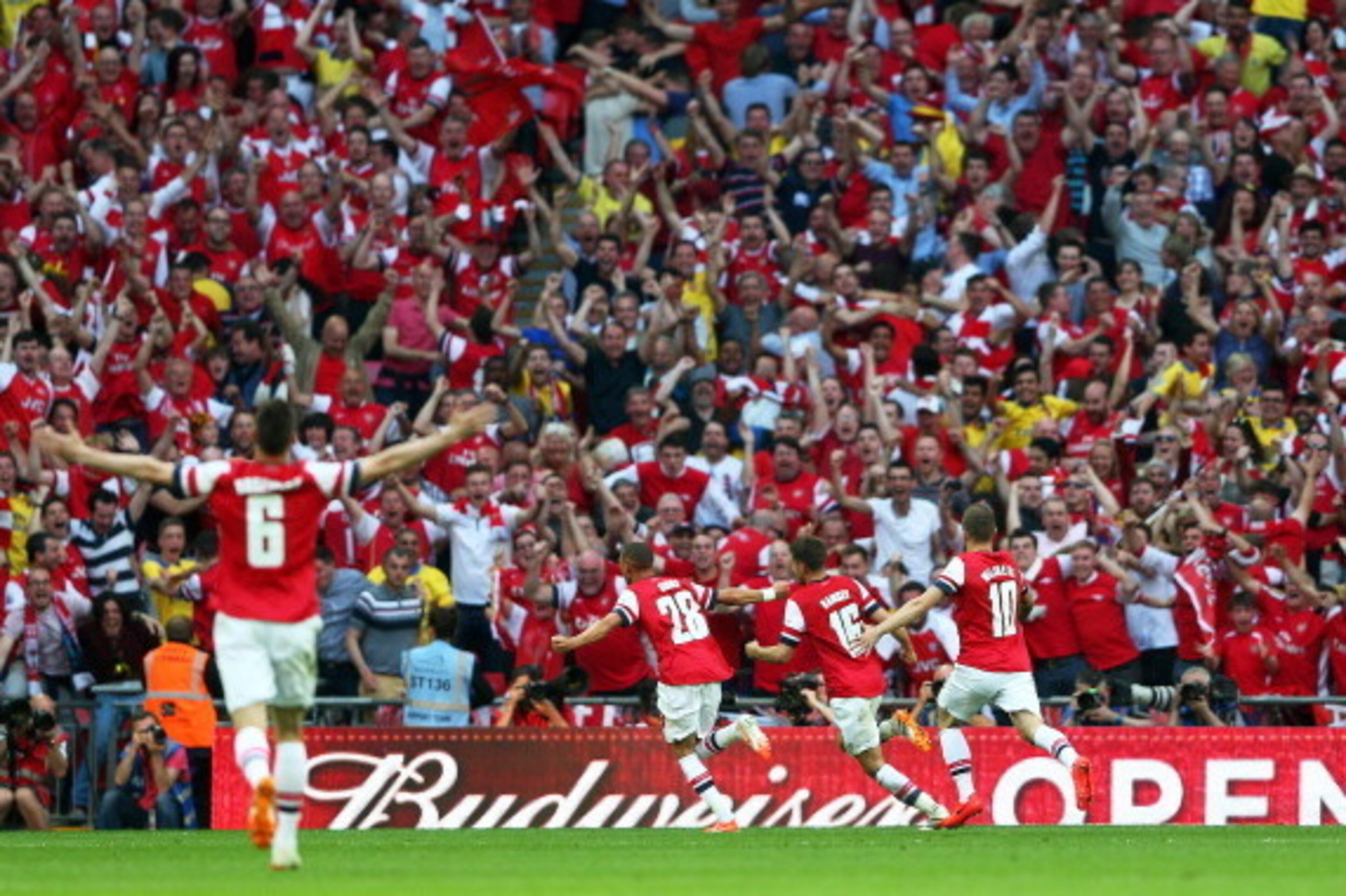 LONDON, ENGLAND - MAY 17:  Aaron Ramsey of Arsenal (16) celebrates with fans and team mates as he scores their third goal during the FA Cup with Budweiser Final match between Arsenal and Hull City at Wembley Stadium on May 17, 2014 in London, England.  (P