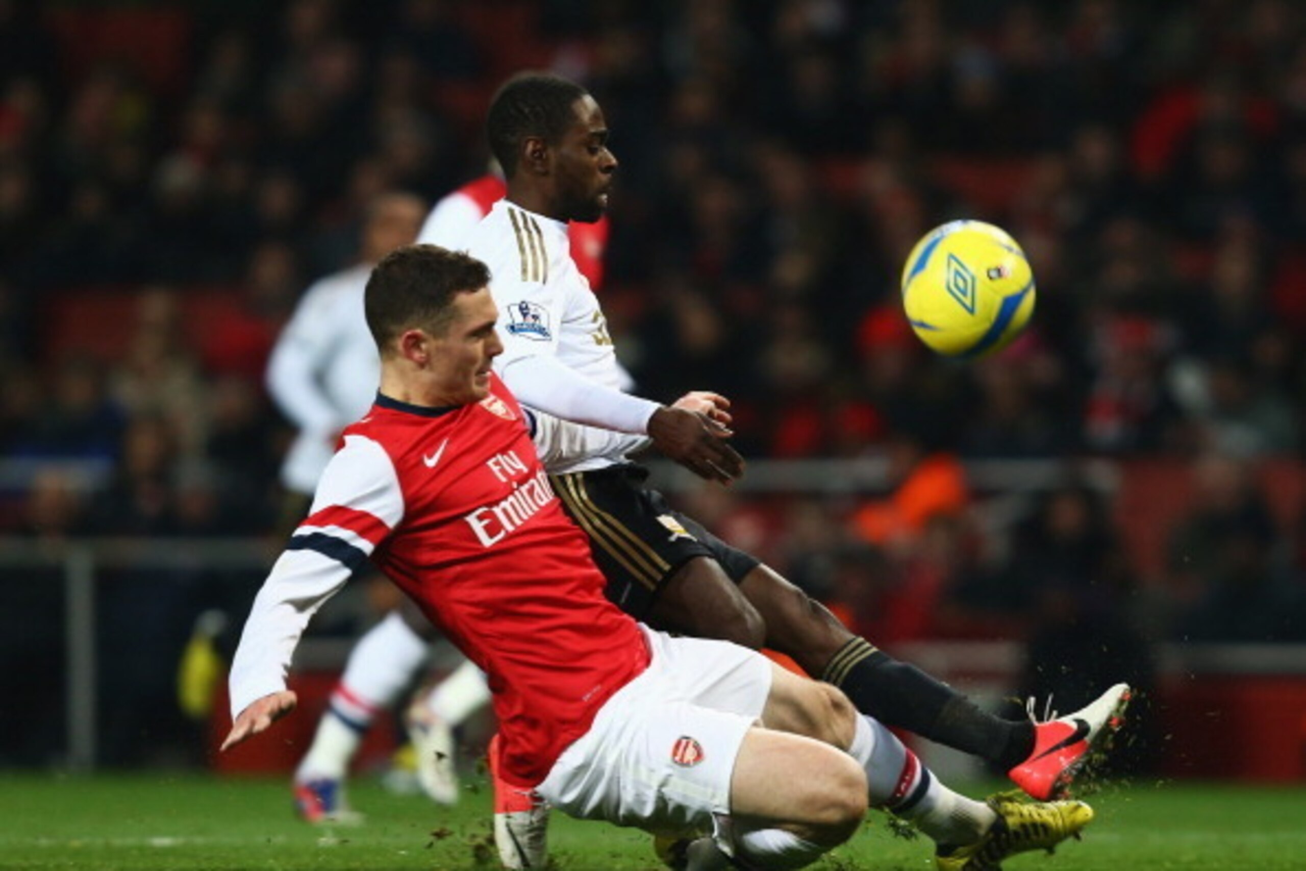 LONDON, ENGLAND - JANUARY 16:  Nathan Dyer of Swansea City is tackled by Thomas Vermaelen of Arsenal during the FA Cup with Budweiser Third Round Replay match between Arsenal and Swansea City at the Emirates Stadium on January 16, 2013 in London, England.