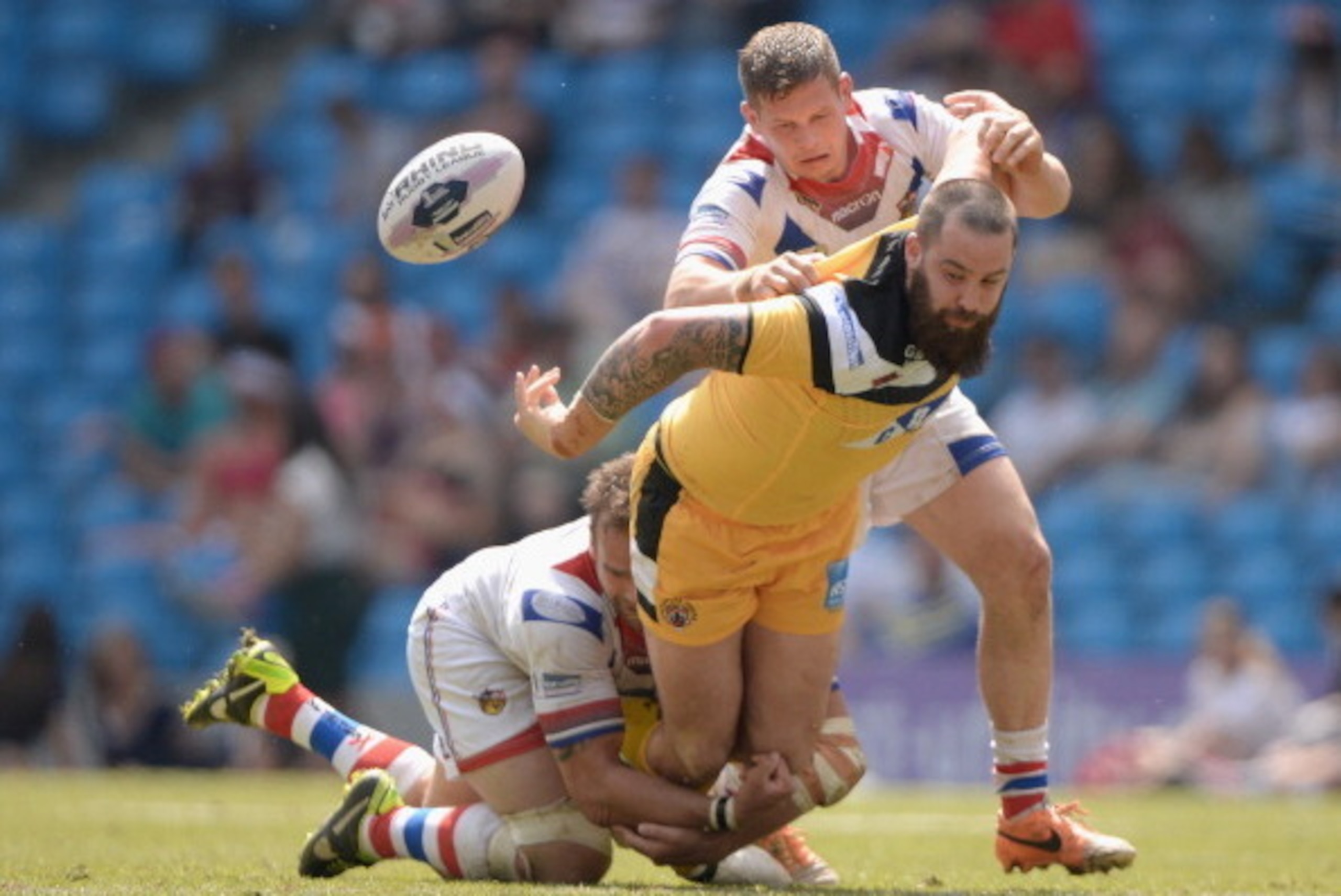 MANCHESTER, ENGLAND - MAY 18: Craig Huby of Castleford Tigers offloads under pressure from Scott Anderson and Danny Washbrook of Wakefield Trinity Wildcats during the Super League match between Wakefield Wildcats and Castleford Tigers at Etihad Stadium o MANCHESTER, ENGLAND - MAY 18: Craig Huby of Castleford Tigers offloads under pressure from Scott Anderson and Danny Washbrook of Wakefield Trinity Wildcats during the Super League match between Wakefield Wildcats and Castleford Tigers at Etihad Stadium o