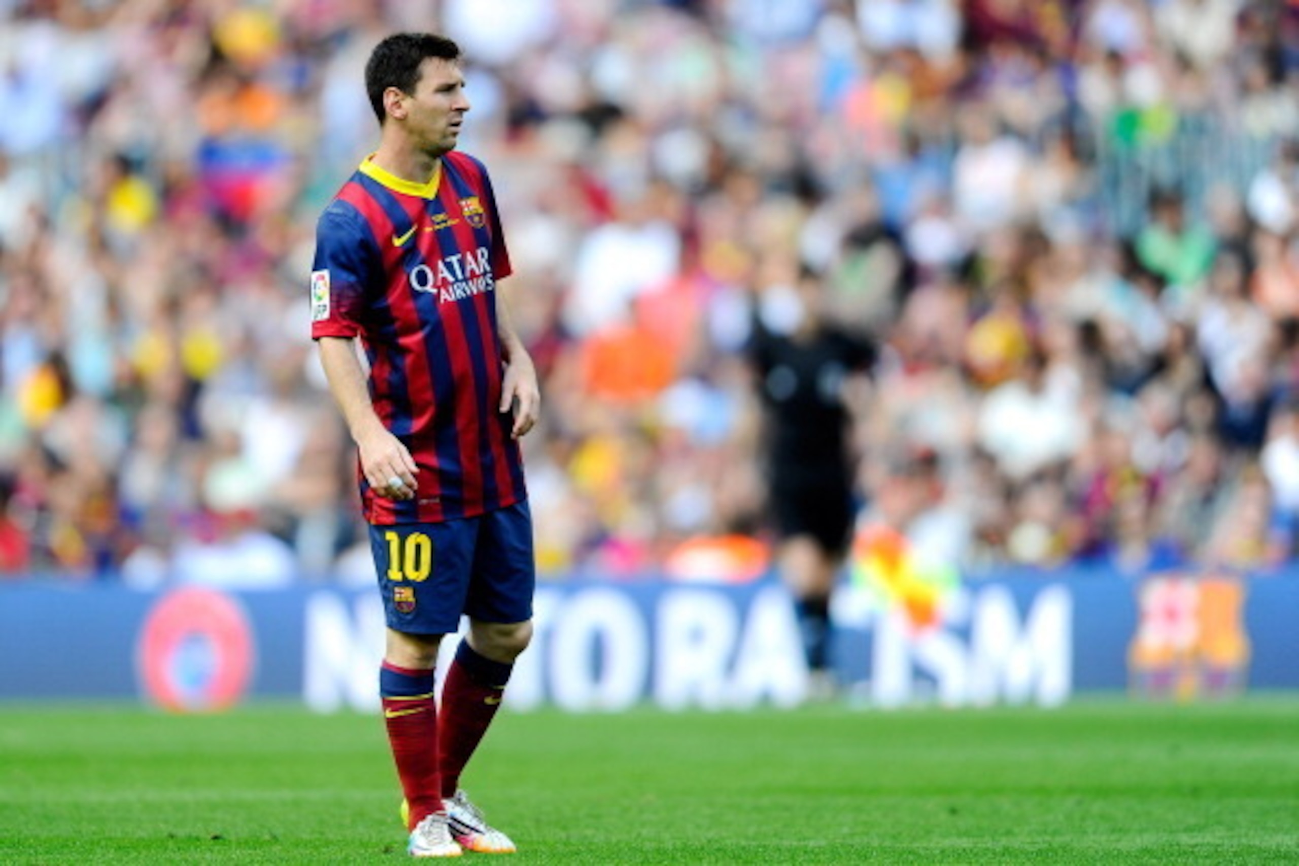 BARCELONA, SPAIN - MAY 03:  Lionel Messi of FC Barcelona looks on, backdropped by an advertising hoarding displaying the message 'no to racism', during the La Liga match between FC Barcelona and Getafe CF at Nou Camp on May 3, 2014 in Barcelona, Spain.  (