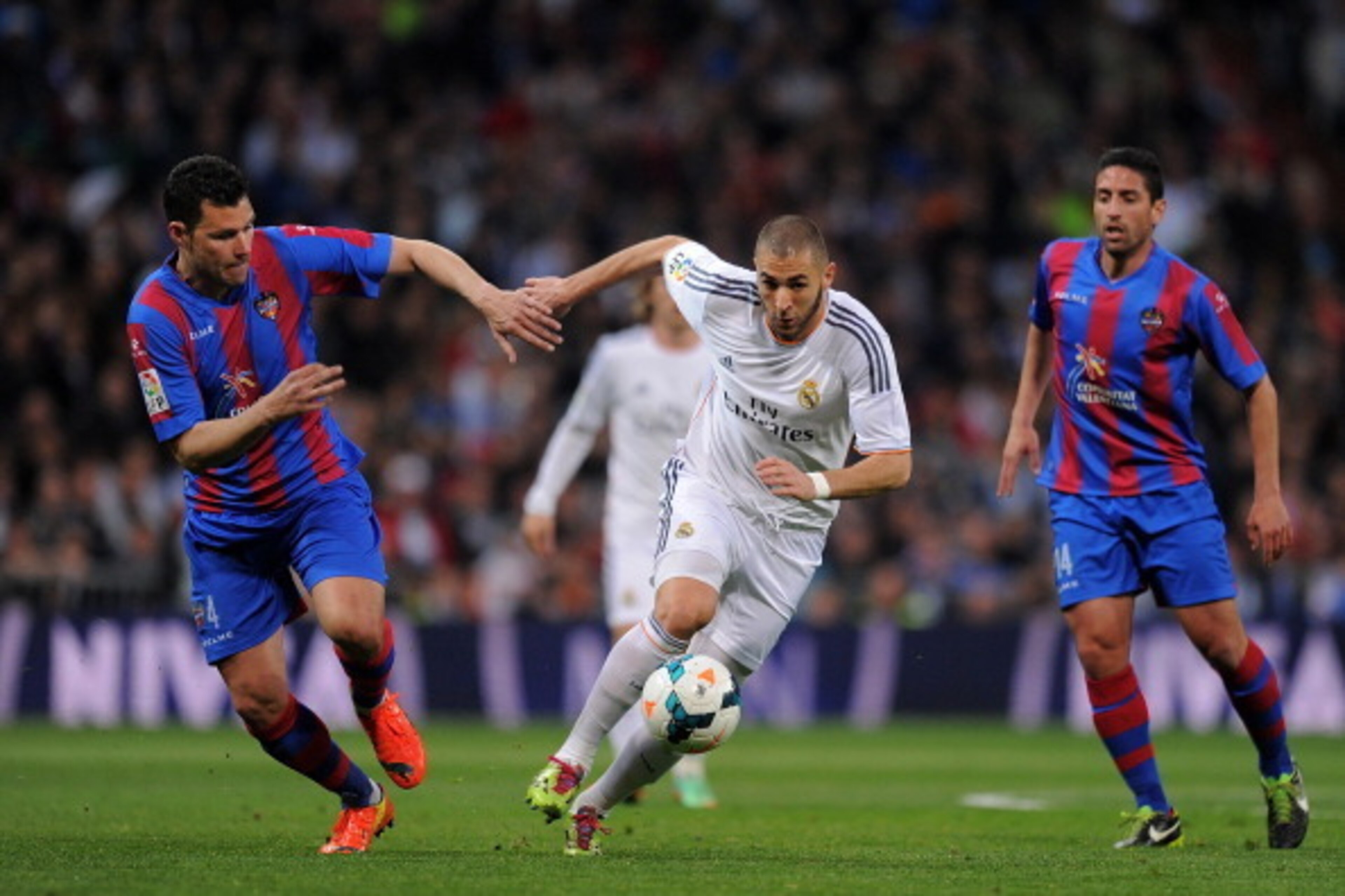 MADRID, SPAIN - MARCH 09:  Karim Benzema (R) of Real Madrid CF is challenged by David Navarro of Levante UD during the La Liga match between Real Madrid CF and Levante UD at Santiago Bernabeu stadium on March 9, 2014 in Madrid, Spain.  (Photo by Denis Doy