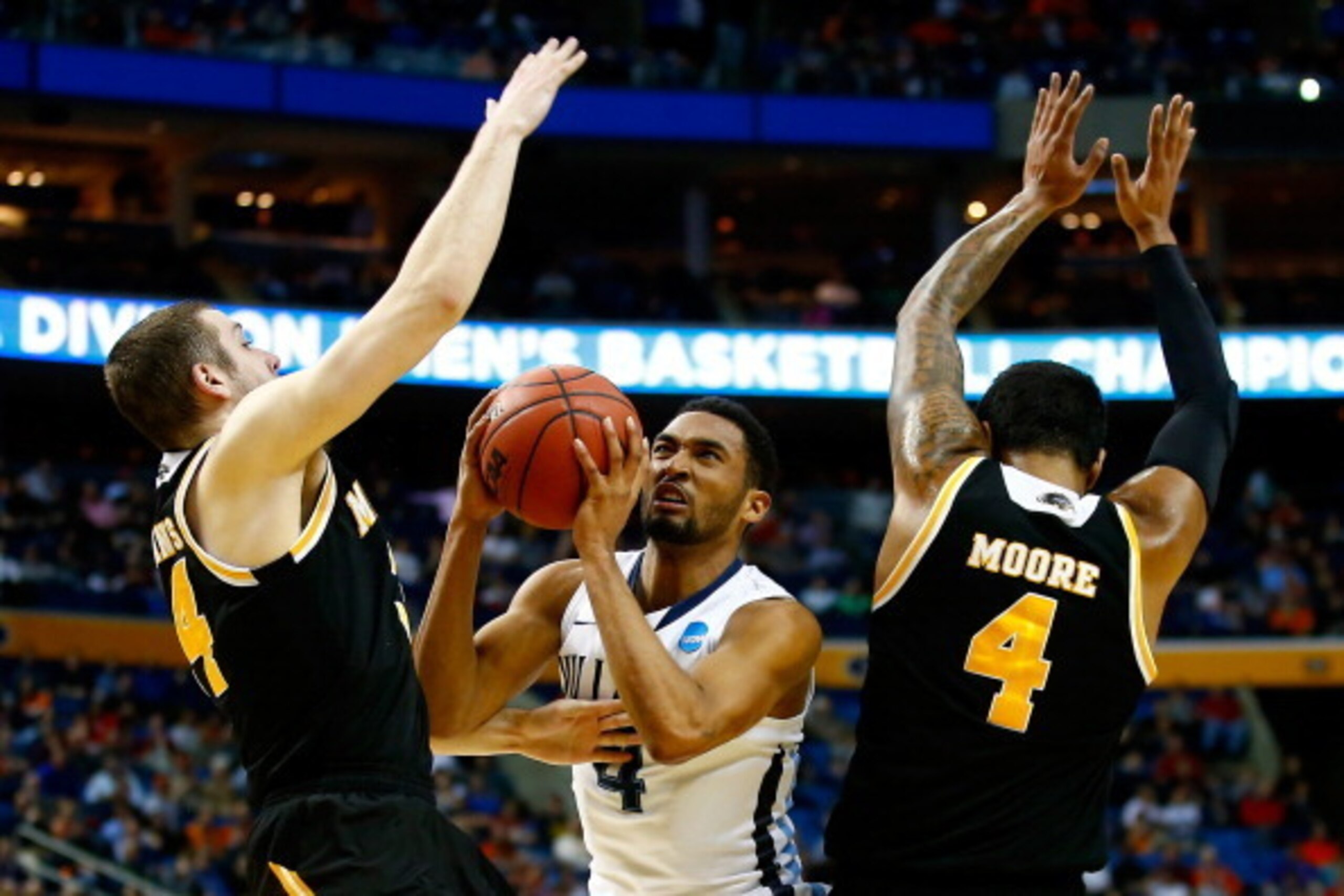BUFFALO, NY - MARCH 20:  Darrun Hilliard II #4 of the Villanova Wildcats goes to the basket as Austin Arians #34 and Malcolm Moore #4 of the Milwaukee Panthers defend during the second round of the 2014 NCAA Men's Basketball Tournament at the First Niagar