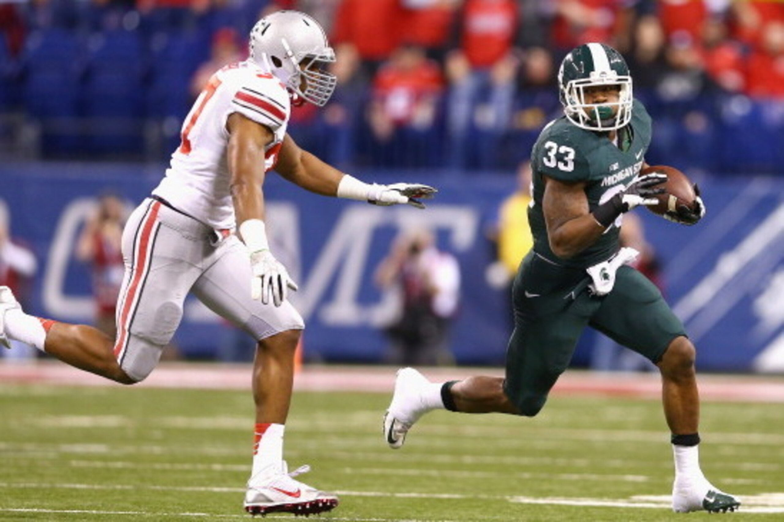 INDIANAPOLIS, IN - DECEMBER 07:  Running back Jeremy Langford #33 of the Michigan State Spartans runs against Joshua Perry #37 of the Ohio State Buckeyes during the Big Ten Conference Championship game at Lucas Oil Stadium on December 7, 2013 in Indianapo