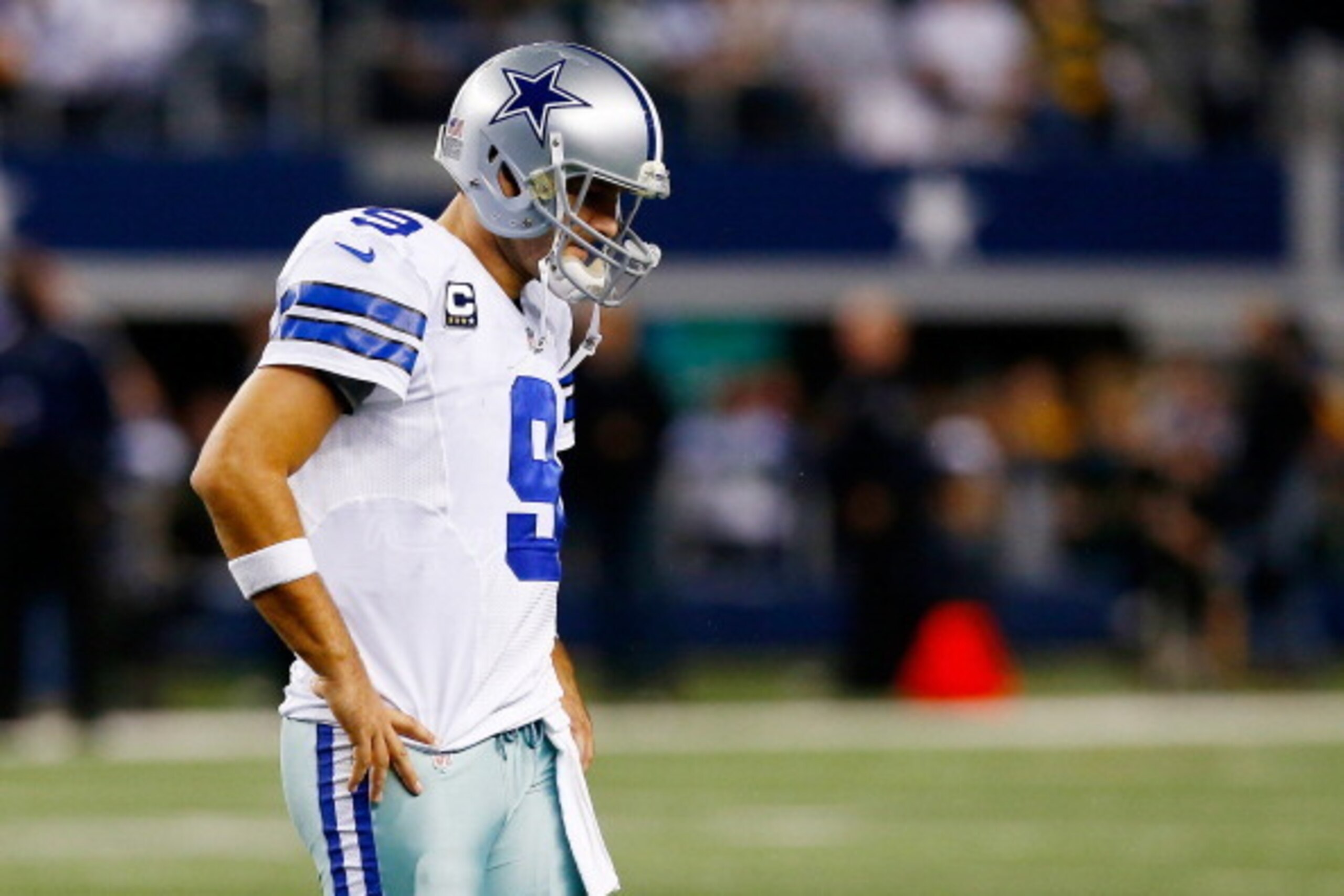 ARLINGTON, TX - DECEMBER 15:  Quarterback Tony Romo #9 of the Dallas Cowboys walks off the field after losing 37-36 to the Green Bay Packers during a game at AT&T Stadium on December 15, 2013 in Arlington, Texas.  (Photo by Tom Pennington/Getty Images)