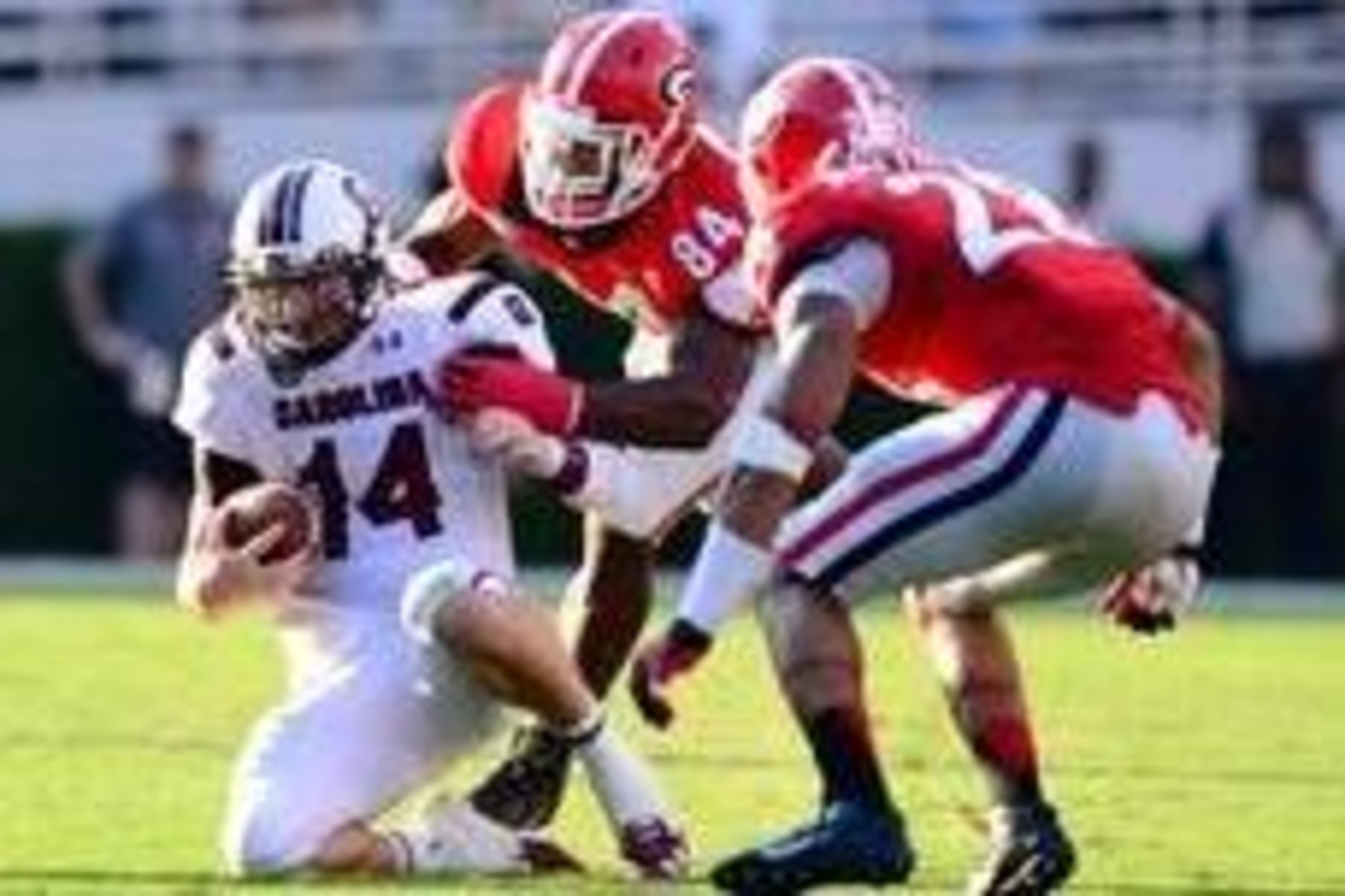 Sep 7, 2013; Athens, GA, USA; South Carolina Gamecocks quarterback Connor Shaw (14) is tackled by Georgia Bulldogs linebacker Leonard Floyd (84) and safety Tray Matthews (28) during the second half at Sanford Stadium. Georgia defeated South Carolina 41-30