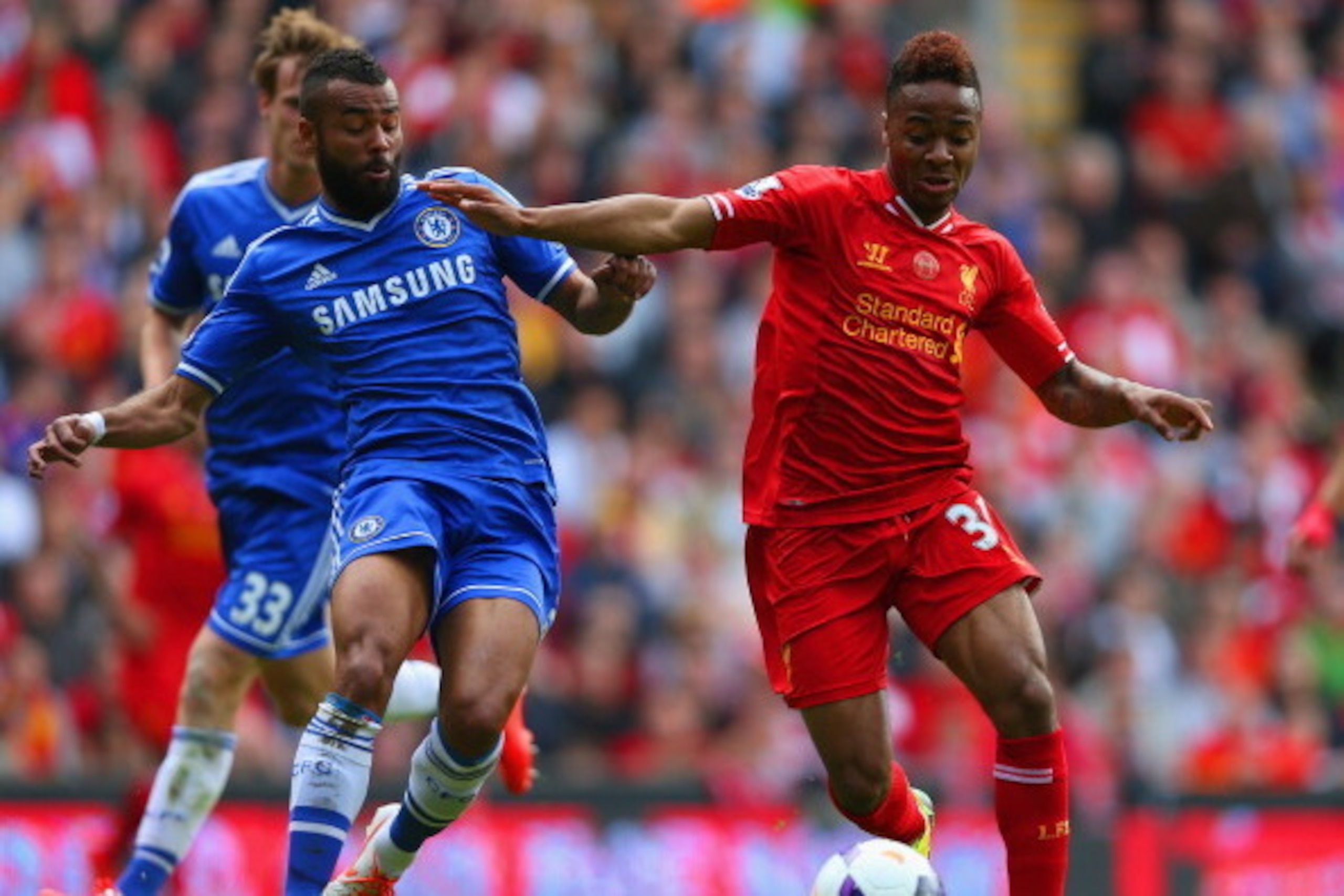 LIVERPOOL, ENGLAND - APRIL 27: Ashley Cole of Chelsea and Raheem Sterling of Liverpool battle for the ball during the Barclays Premier League match between Liverpool and Chelsea at Anfield on April 27, 2014 in Liverpool, England.  (Photo by Clive Brunskil