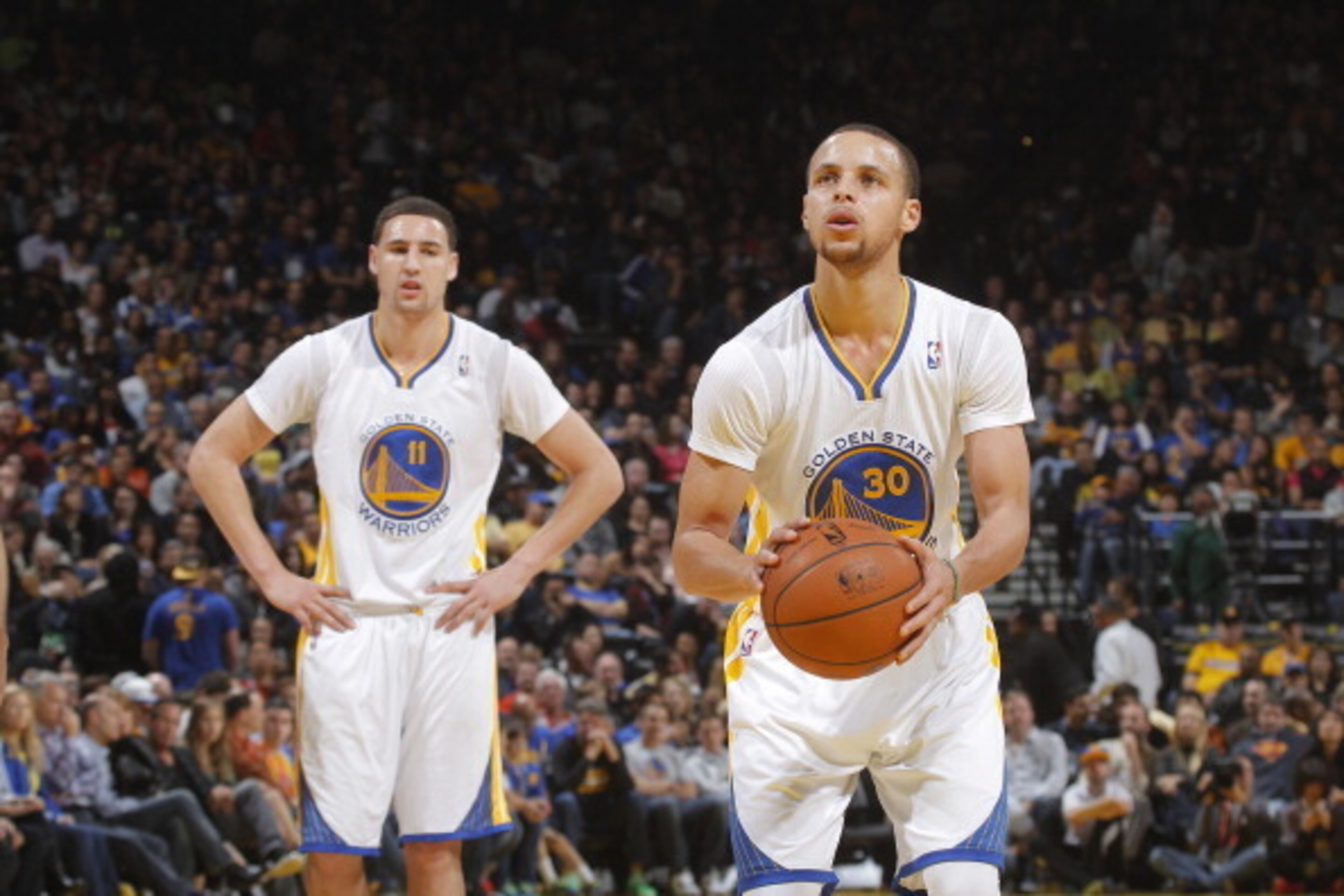 OAKLAND, CA - MARCH 22: Klay Thompson #11 of the Golden State Warriors watches teammate Stephen Curry #30 shoot a attempts a free throw shot against the San Antonio Spurs on March 22, 2014 at Oracle Arena in Oakland, California. NOTE TO USER: User express