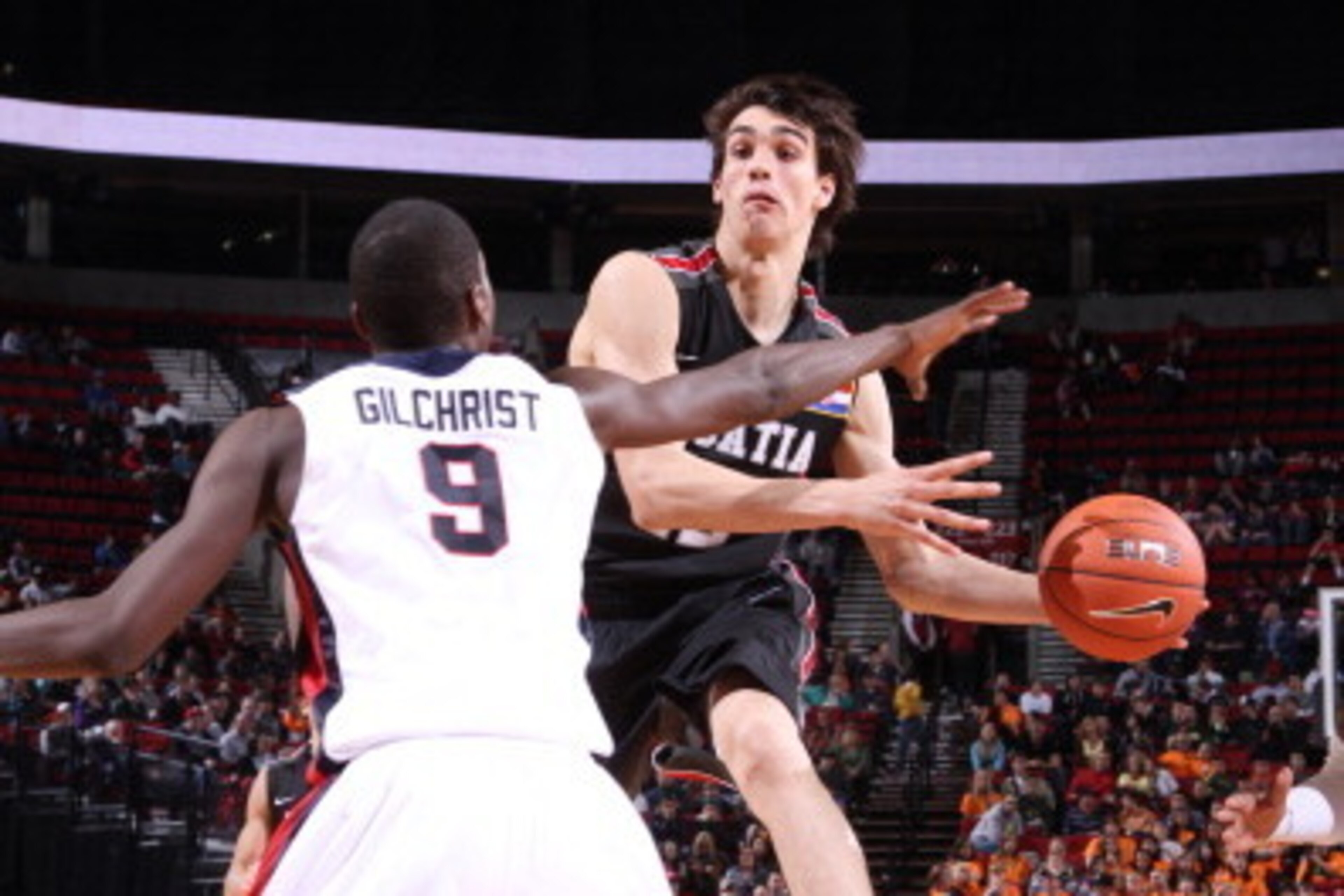 PORTLAND, OR - APRIL 9: Dario Saric #12 of the World Select Team passes against Michael Gilchrist #9 of the USA Junior National Select Team during the game on April 9, 2011 at the Rose Garden Arena in Portland, Oregon. NOTE TO USER: User expressly acknowl