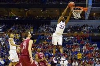 Mar 21, 2014; St. Louis, MO, USA; Kansas Jayhawks guard Andrew Wiggins (22) dunks the ball past Eastern Kentucky Colonels guard Marcus Lewis (12) in the first half during the 2nd round of the 2014 NCAA Men's  Basketball Championship at Scottrade Center. M