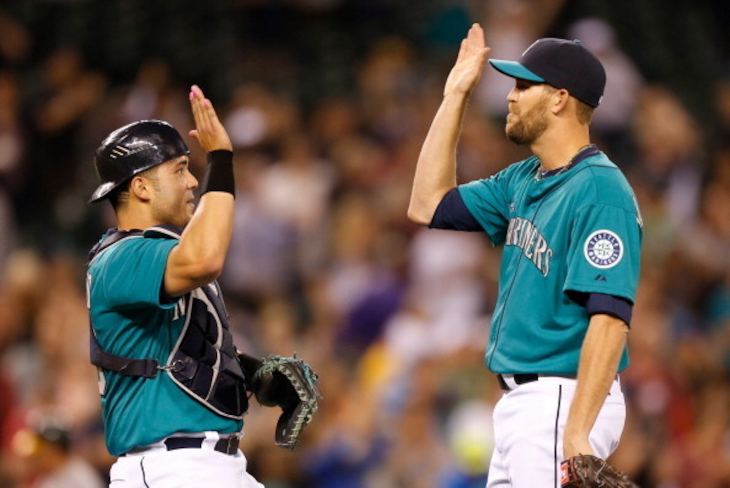 SEATTLE, WA - MAY 10:  Closing pitcher Tom Wilhelmsen #54 (R) of the Seattle Mariners celebrates with catcher Jesus Montero #63 after defeating the Oakland Athletics 6-3 at Safeco Field on May 10, 2013 in Seattle, Washington.  (Photo by Otto Greule Jr/Get