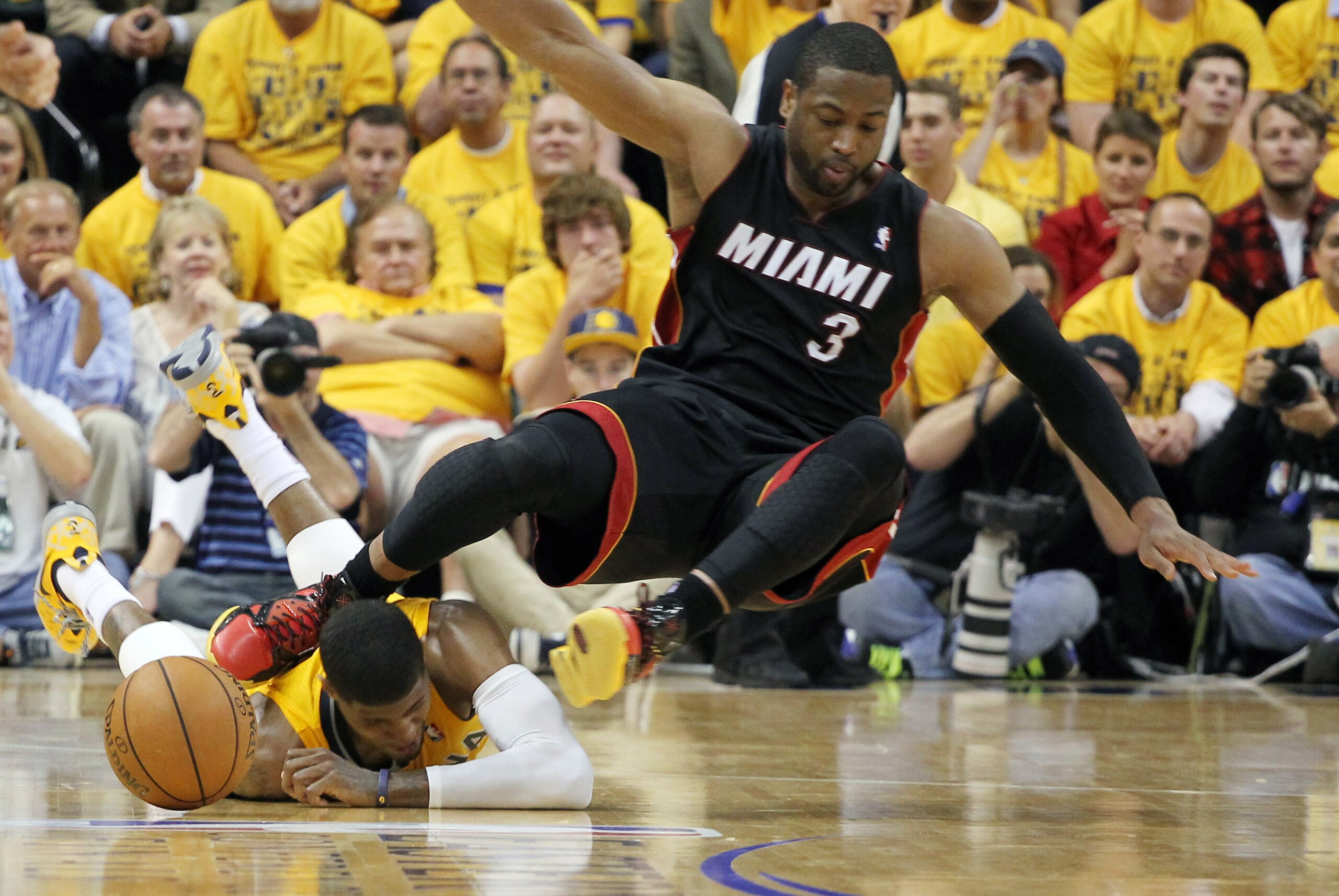 May 20, 2014; Indianapolis, IN, USA; Indiana Pacers forward Paul George (24) gets hit in the head by Miami Heat guard Dwayne Wade (3) during a scramble for a loose ball in game two of the Eastern Conference Finals of the 2014 NBA Playoffs at Bankers Life