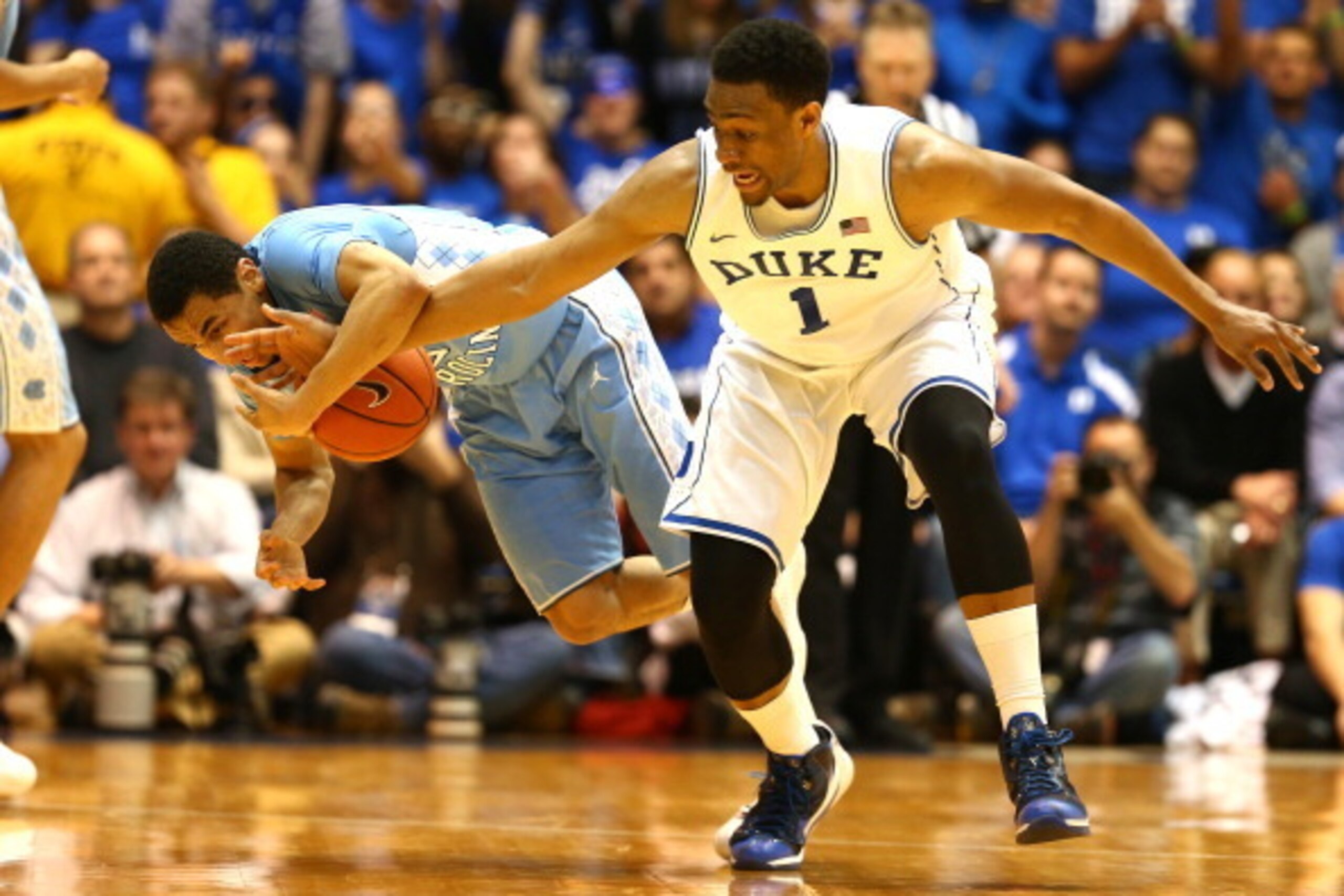 DURHAM, NC - MARCH 08:  Marcus Paige #5 of the North Carolina Tar Heels and Jabari Parker #1 of the Duke Blue Devils go after a loose ball during their game at Cameron Indoor Stadium on March 8, 2014 in Durham, North Carolina.  (Photo by Streeter Lecka/Ge